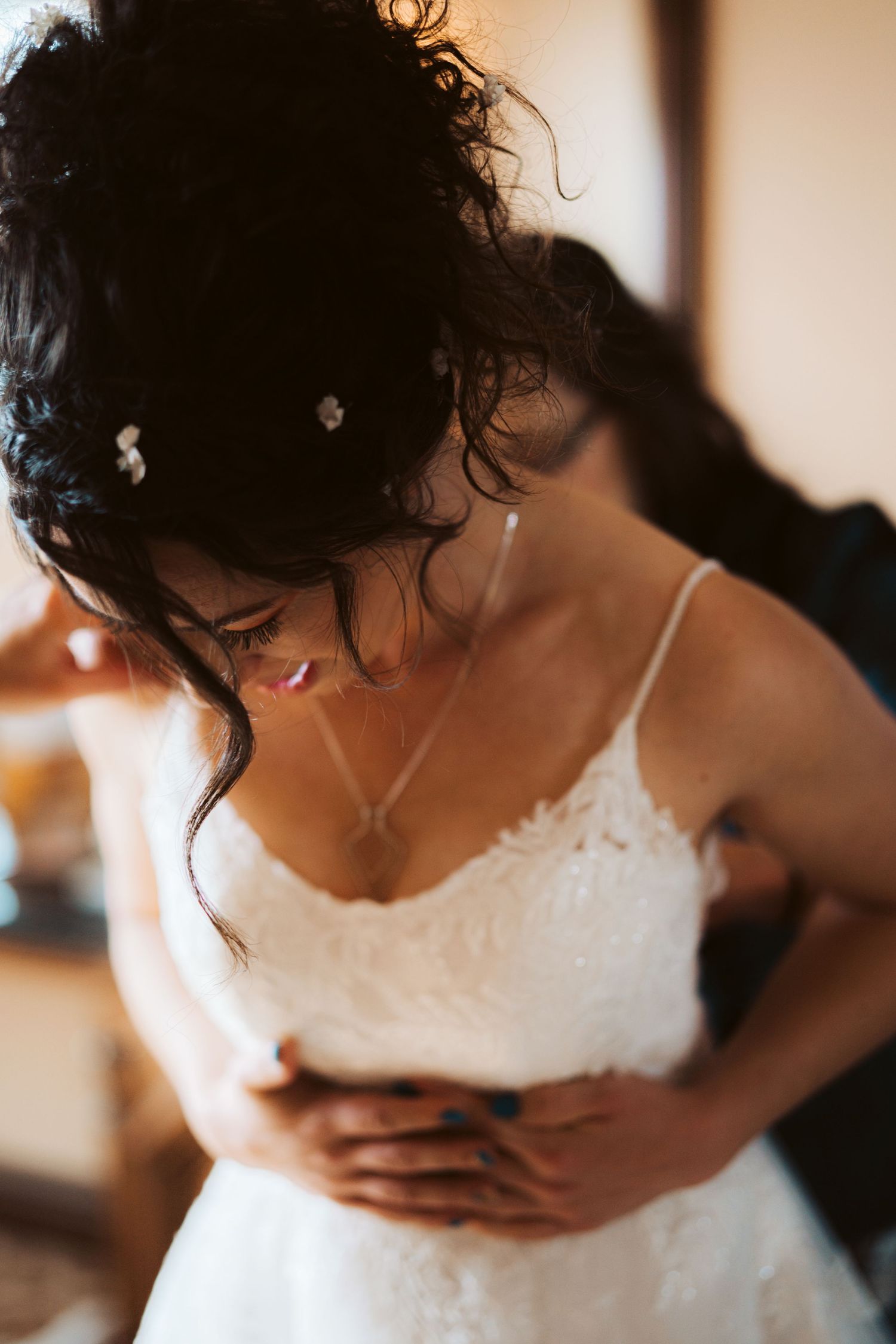 Close-up portrait showing delicate details of a bride's wedding dress bodice.