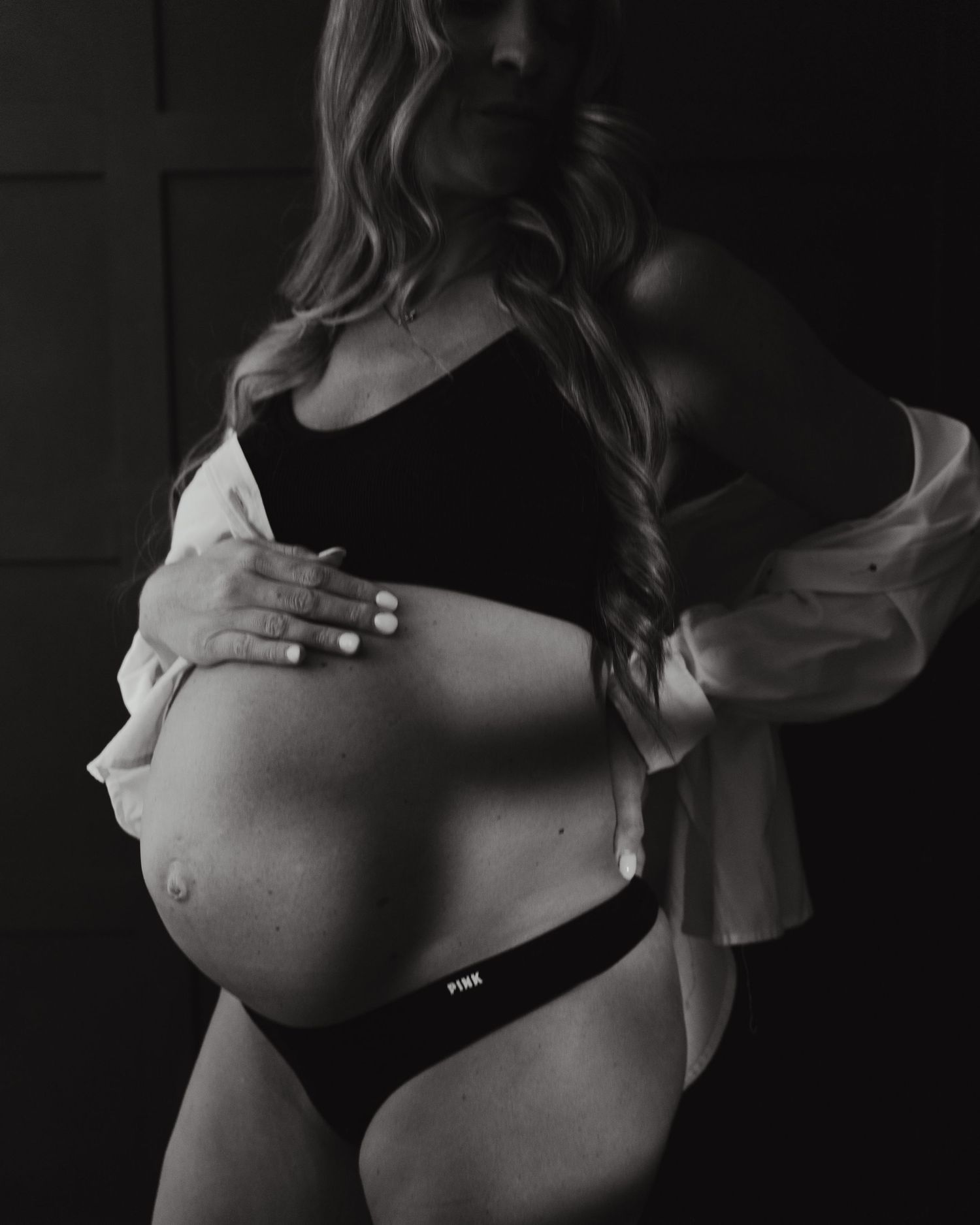 Black and white artistic maternity photo series showing a pregnant belly in silhouette from different angles.