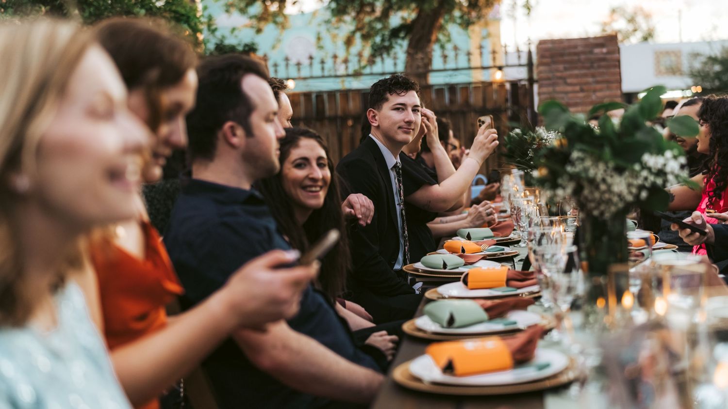 Blurred outdoor dining scene with string lights and table settings.