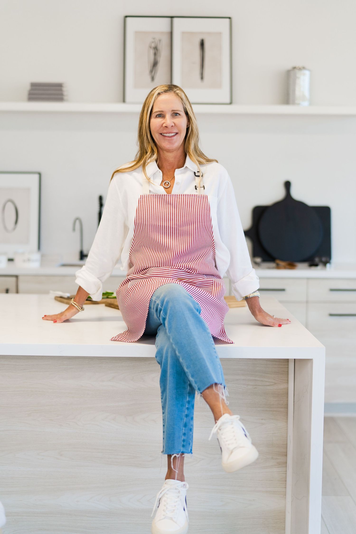 A series of photos showing someone in pink striped apron and jeans sitting casually on a white desk in a bright kitchen.