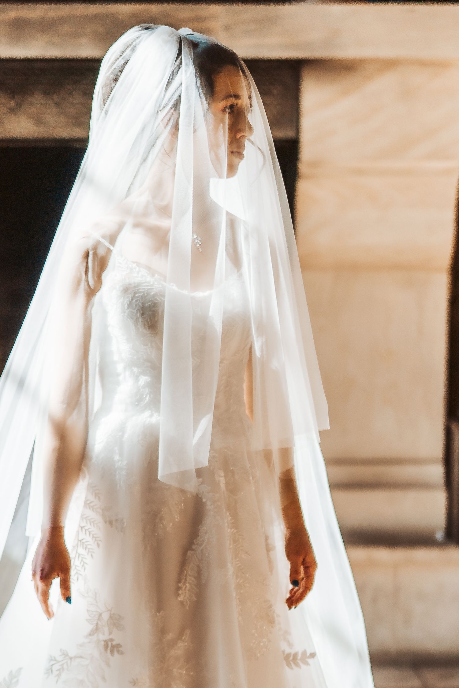 Elegant white wedding dress and veil photographed in soft natural light.