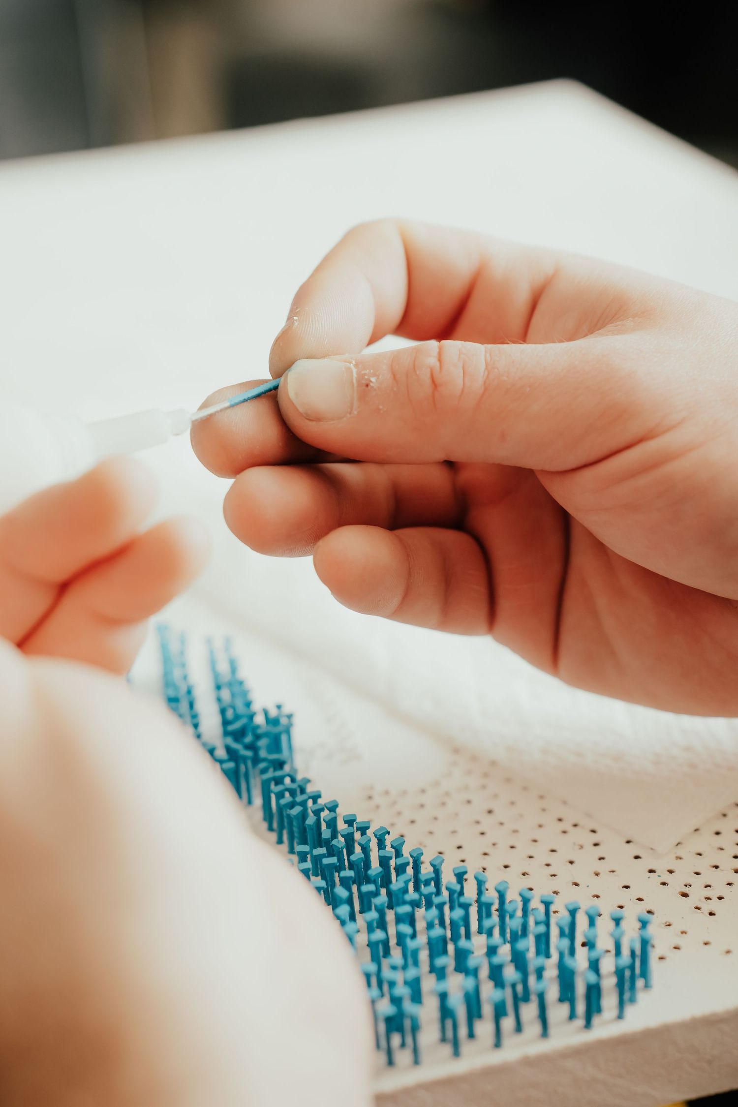 Hands carefully placing pins to create a detailed artwork pattern. Session in Anthem Arizona