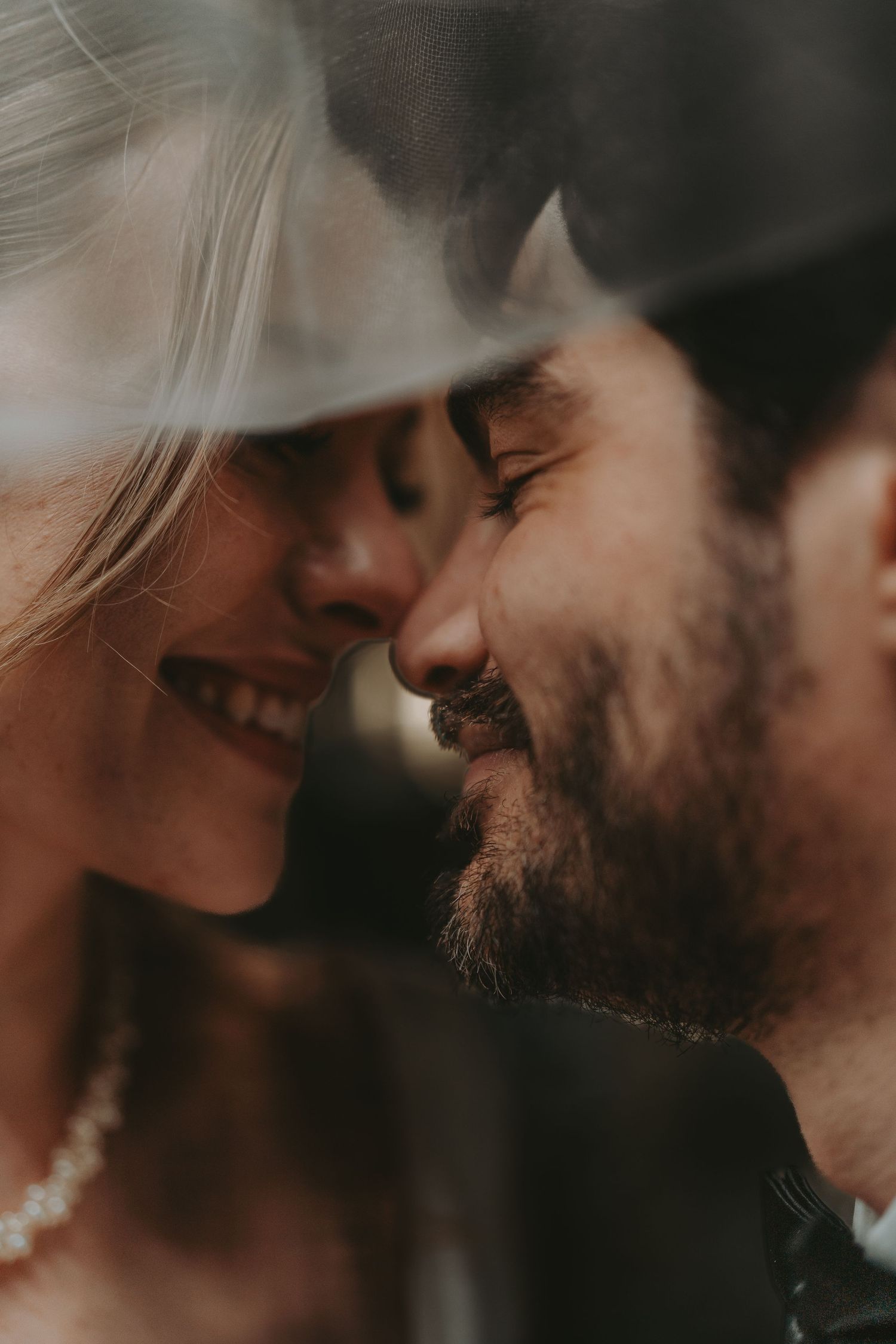 An intimate close-up moment between a couple sharing a tender smile.