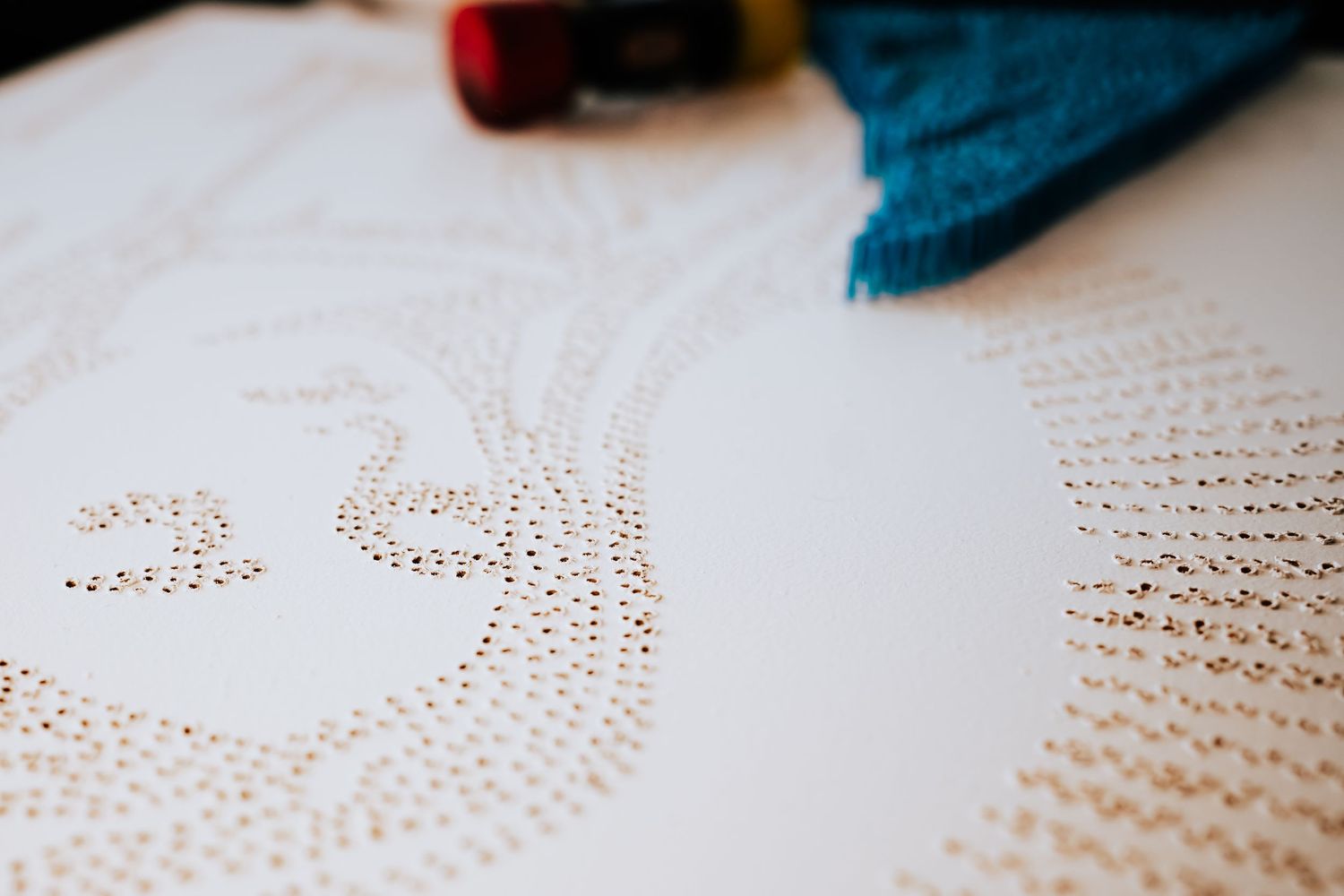 Close-up view of a pinpoint art piece being created on white paper. Session in Anthem Arizona