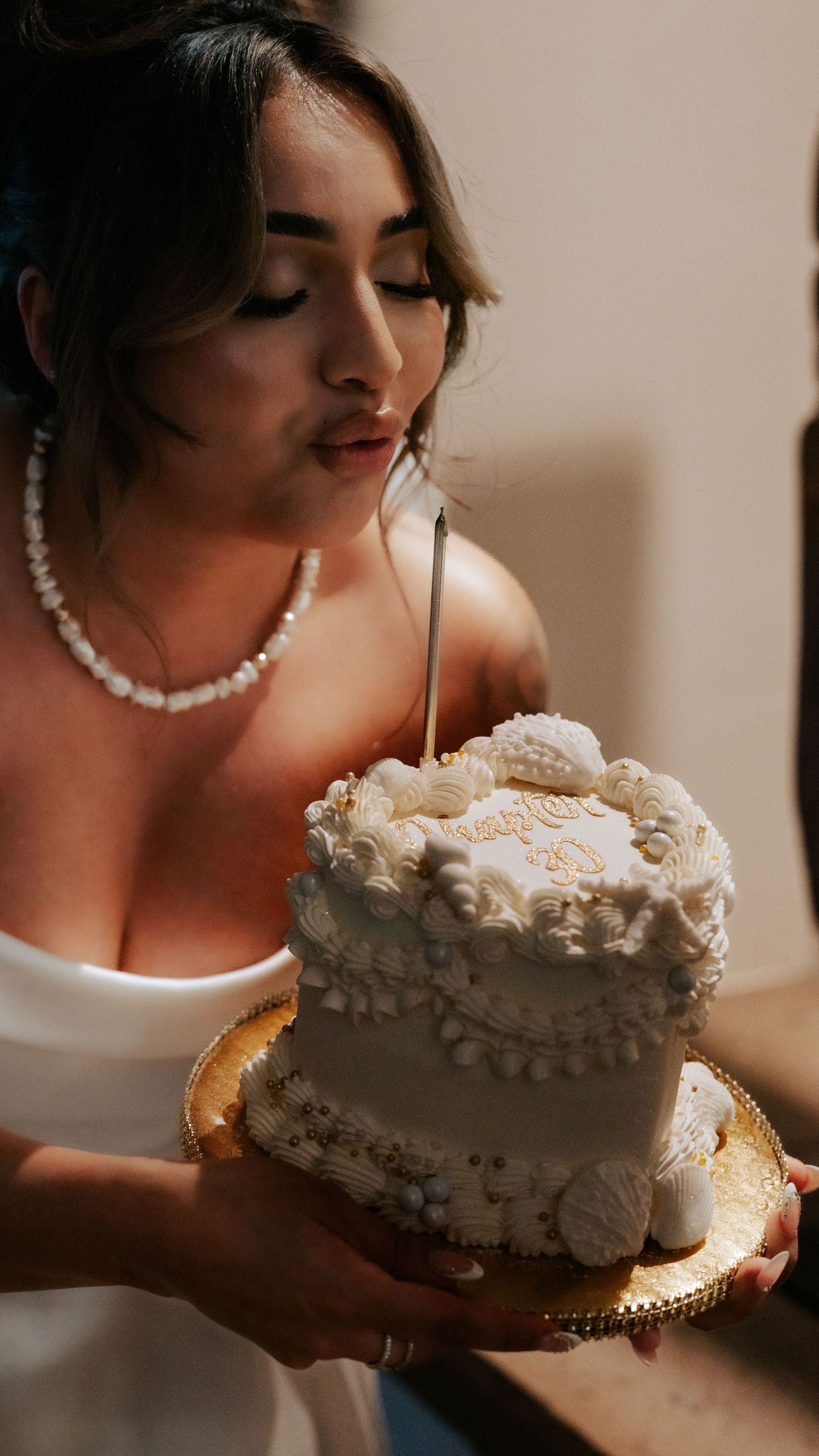 Close-up shots of a white frosted cake being held by someone wearing a pearl necklace. Session in Phoenix Arizona