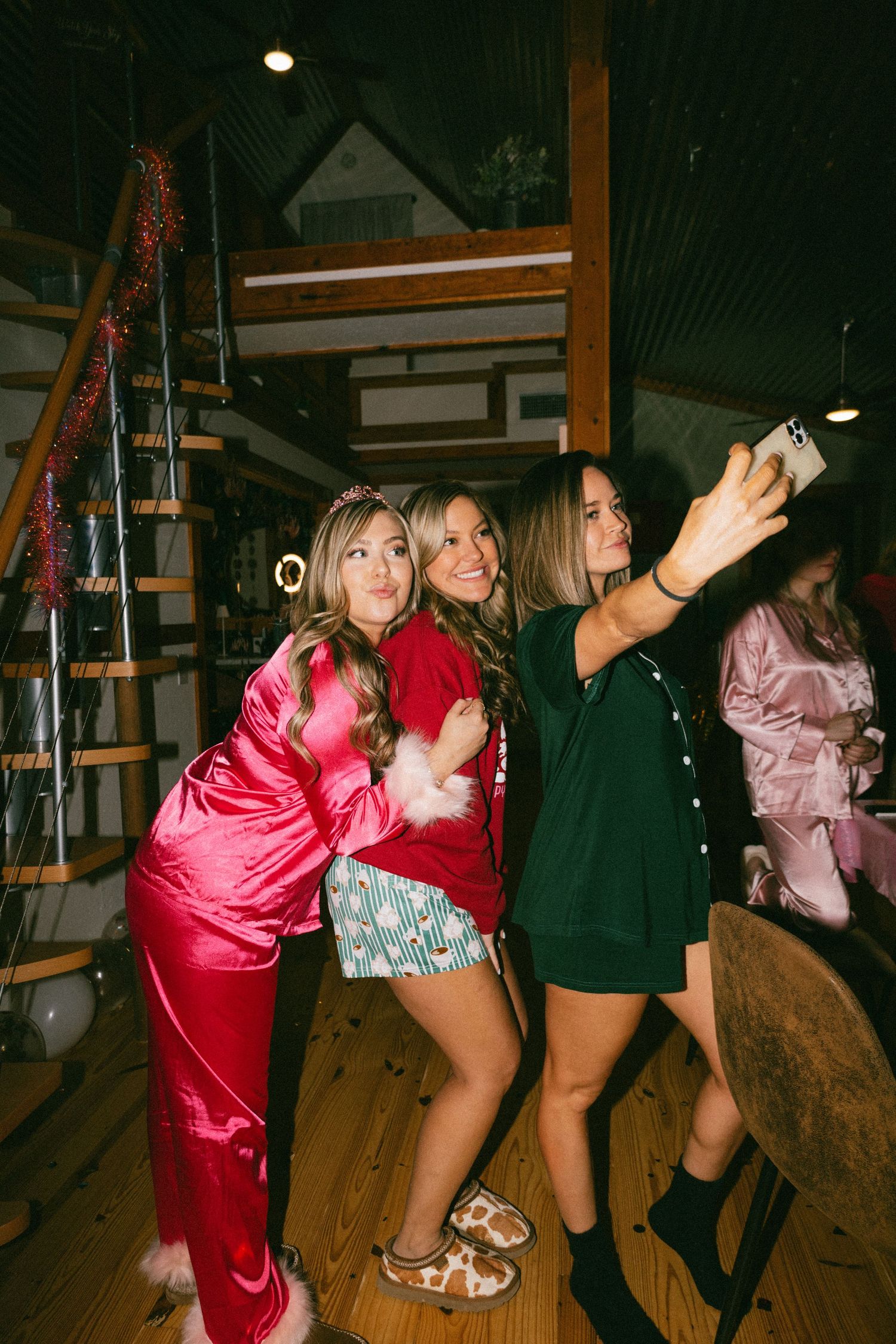 Group celebrating at party with glittery decorations and spiral staircase.