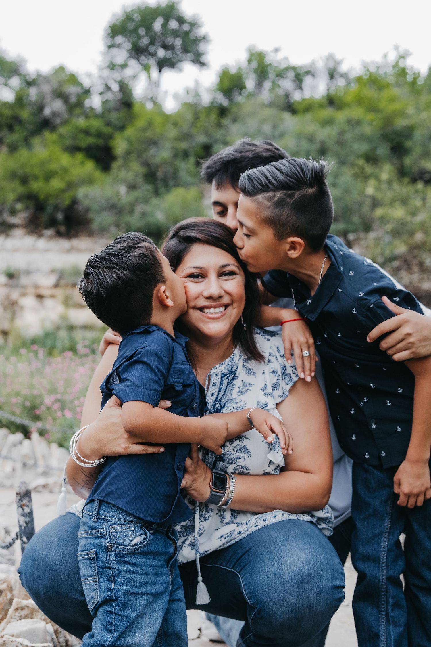 Candid outdoor family photoshoot showing joyful embraces and natural interactions.