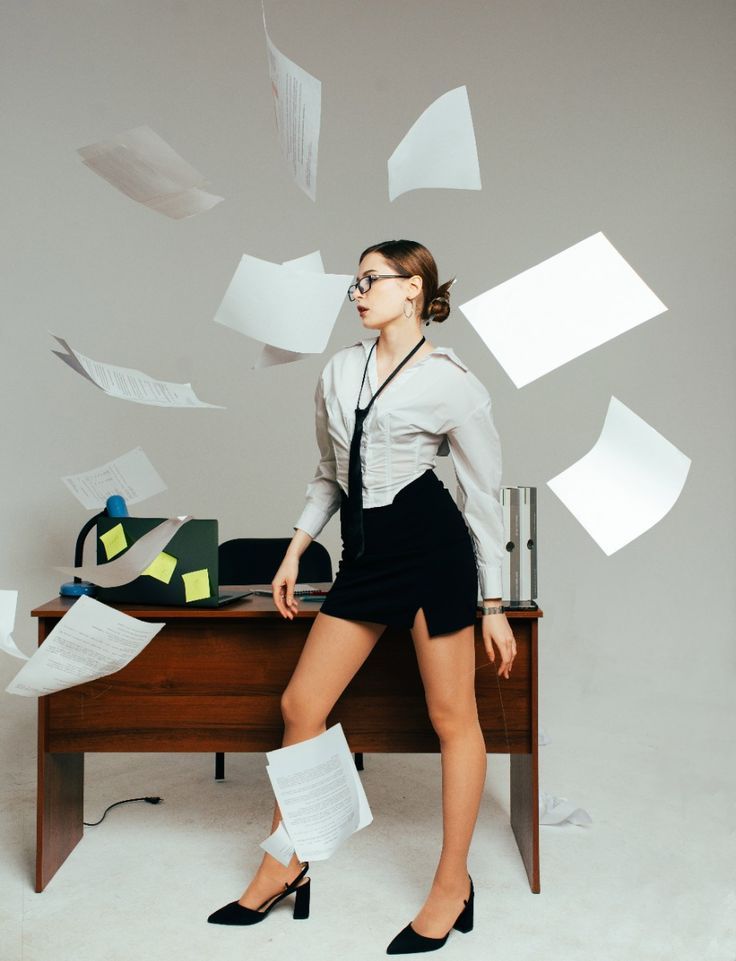 Business professional with flying papers creates dynamic motion scene in office setting.