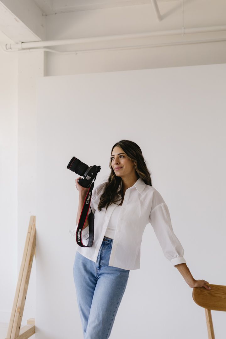 Portrait session showing casual fashion with blue jeans and white shirt against minimal white studio backdrop.
