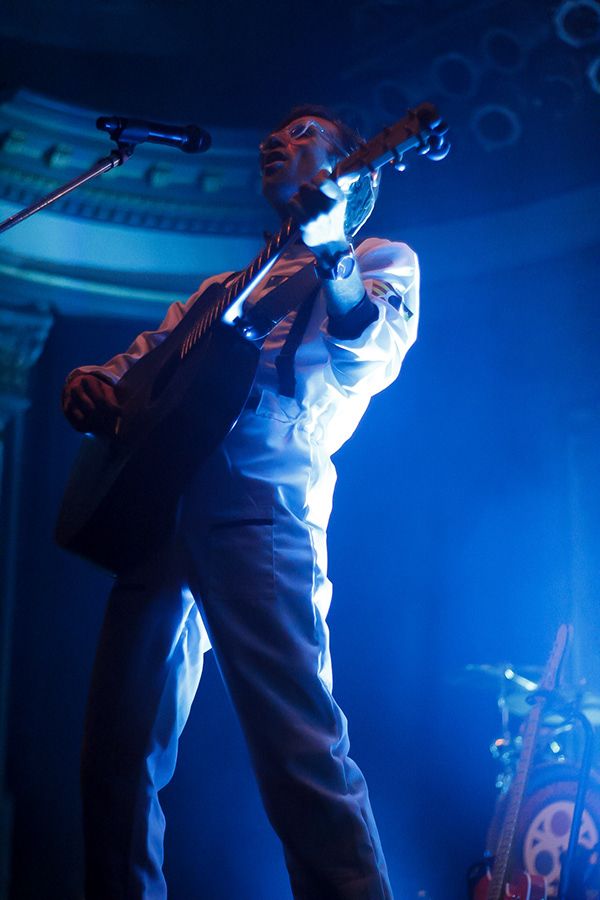 A man playing guitar and singing into a microphone