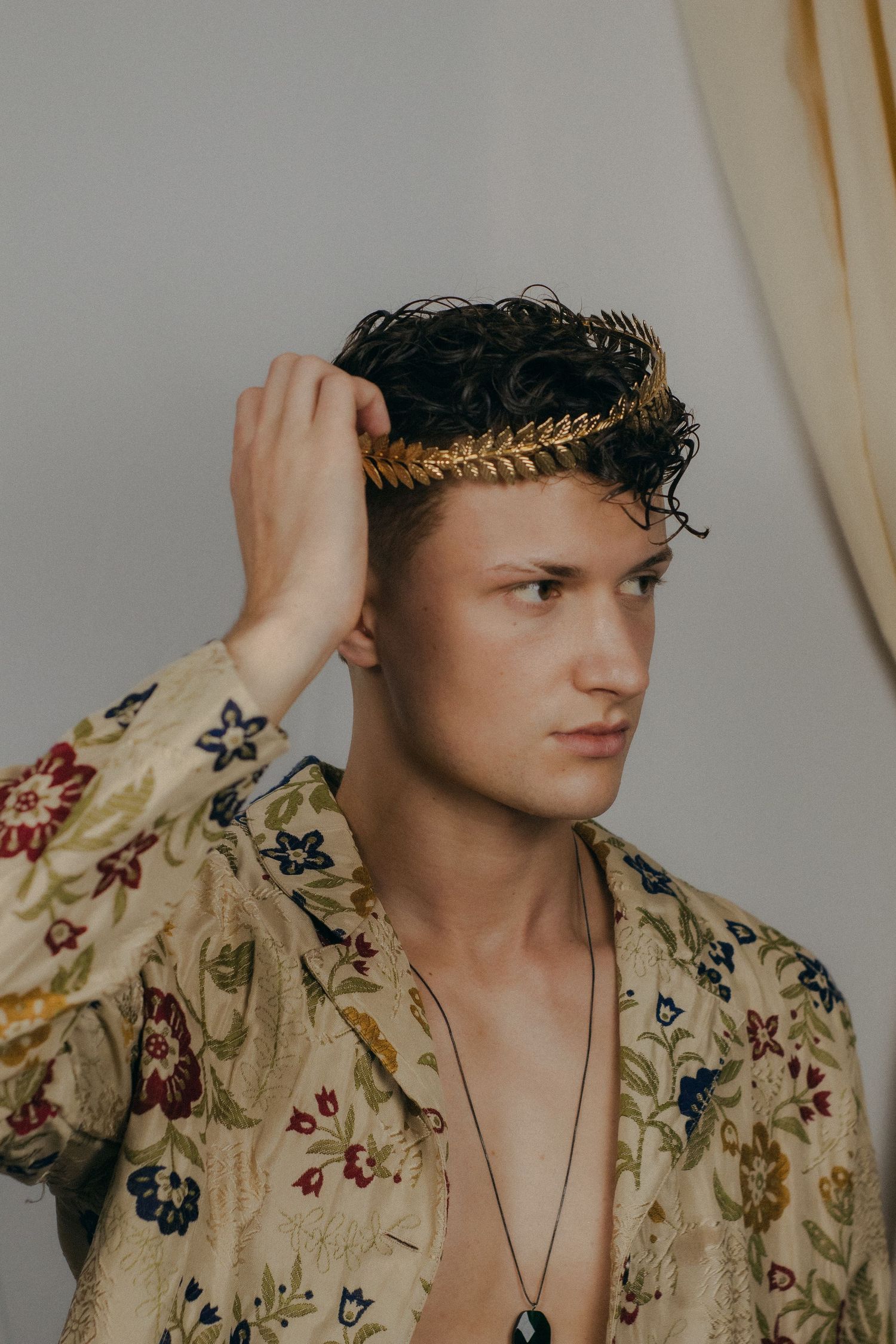 A man holding his crown in front of a white background