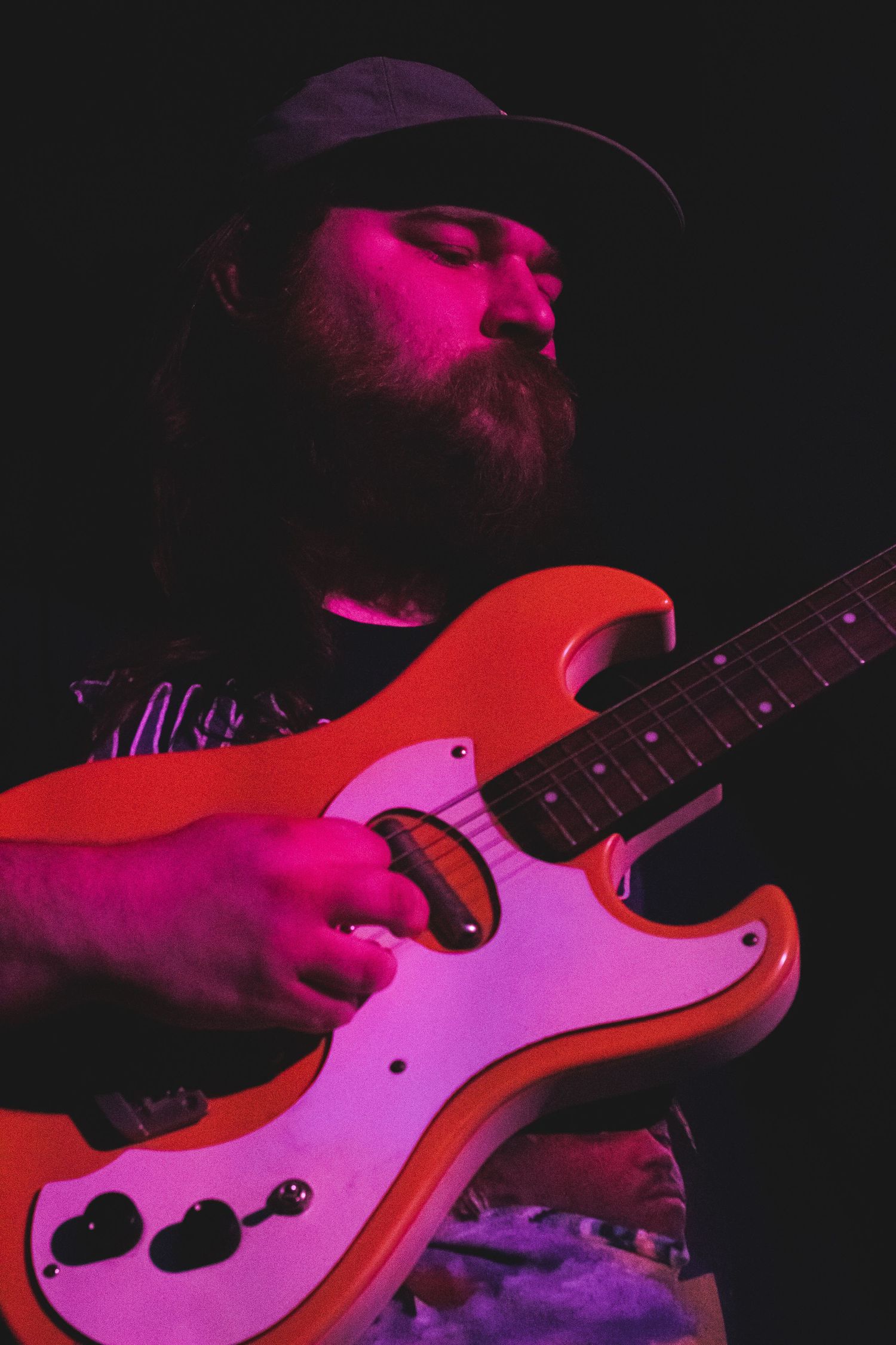 A bearded man playing guitar