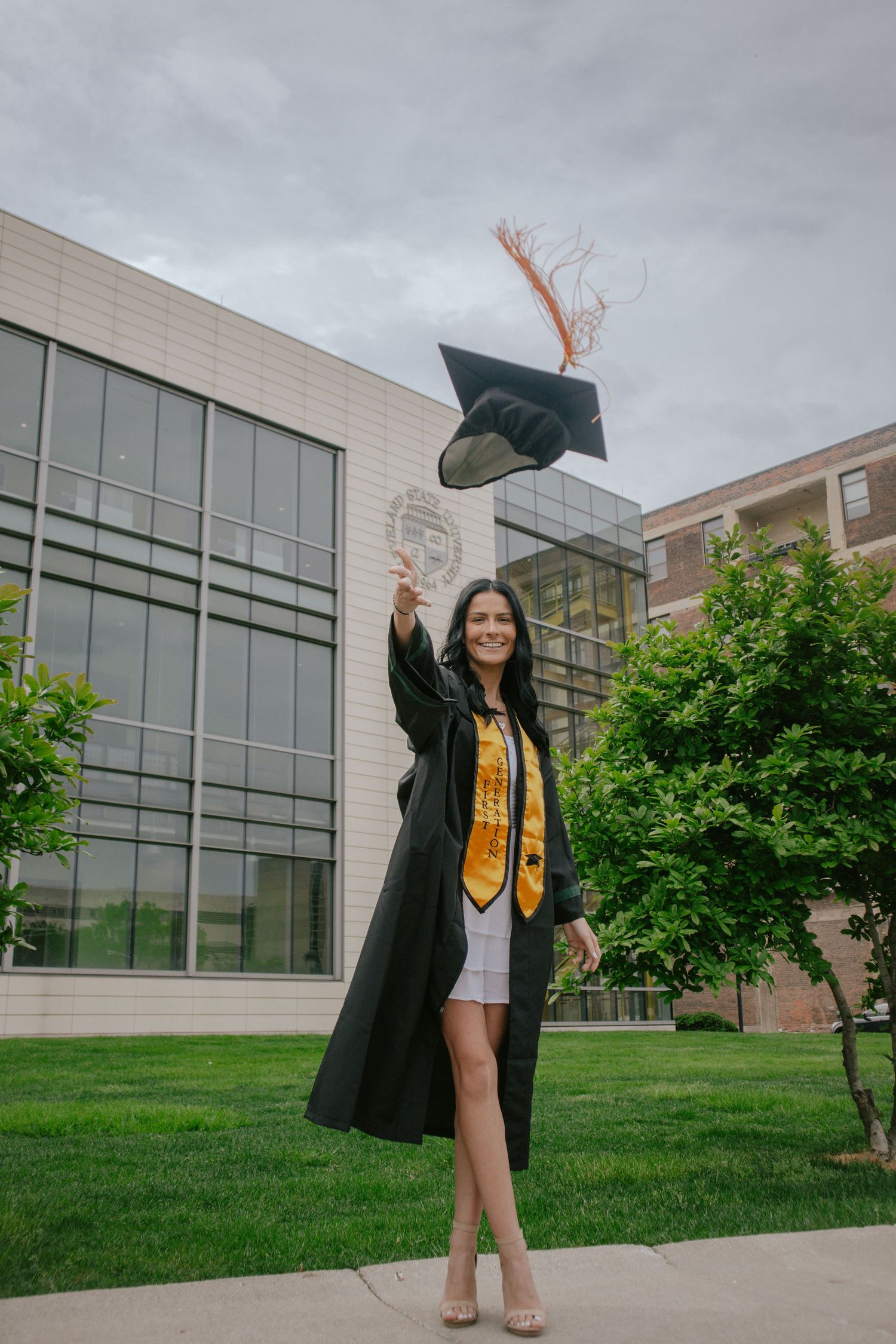 A woman tossing her cap into the air