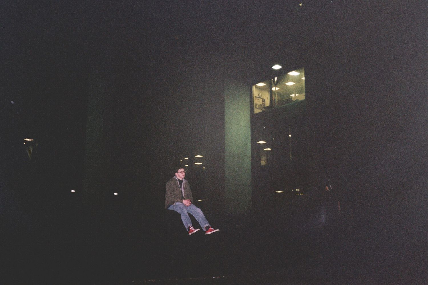 A man sitting in front of a building