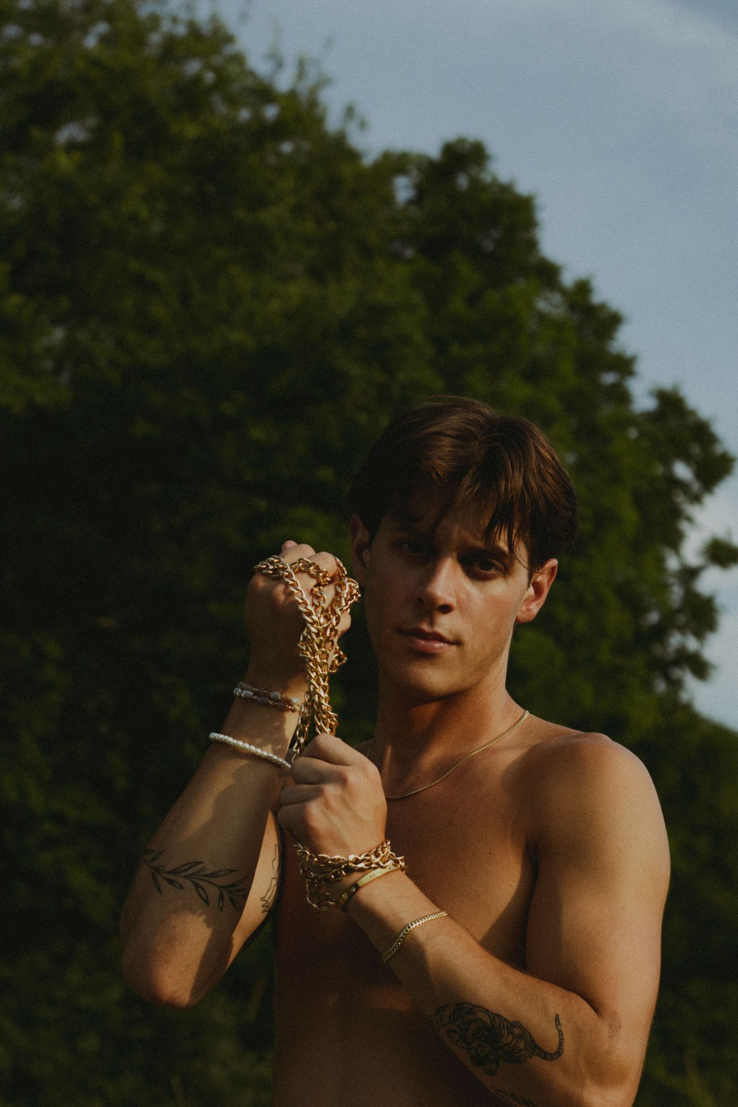 A man with his hands tied together with a golden chain.