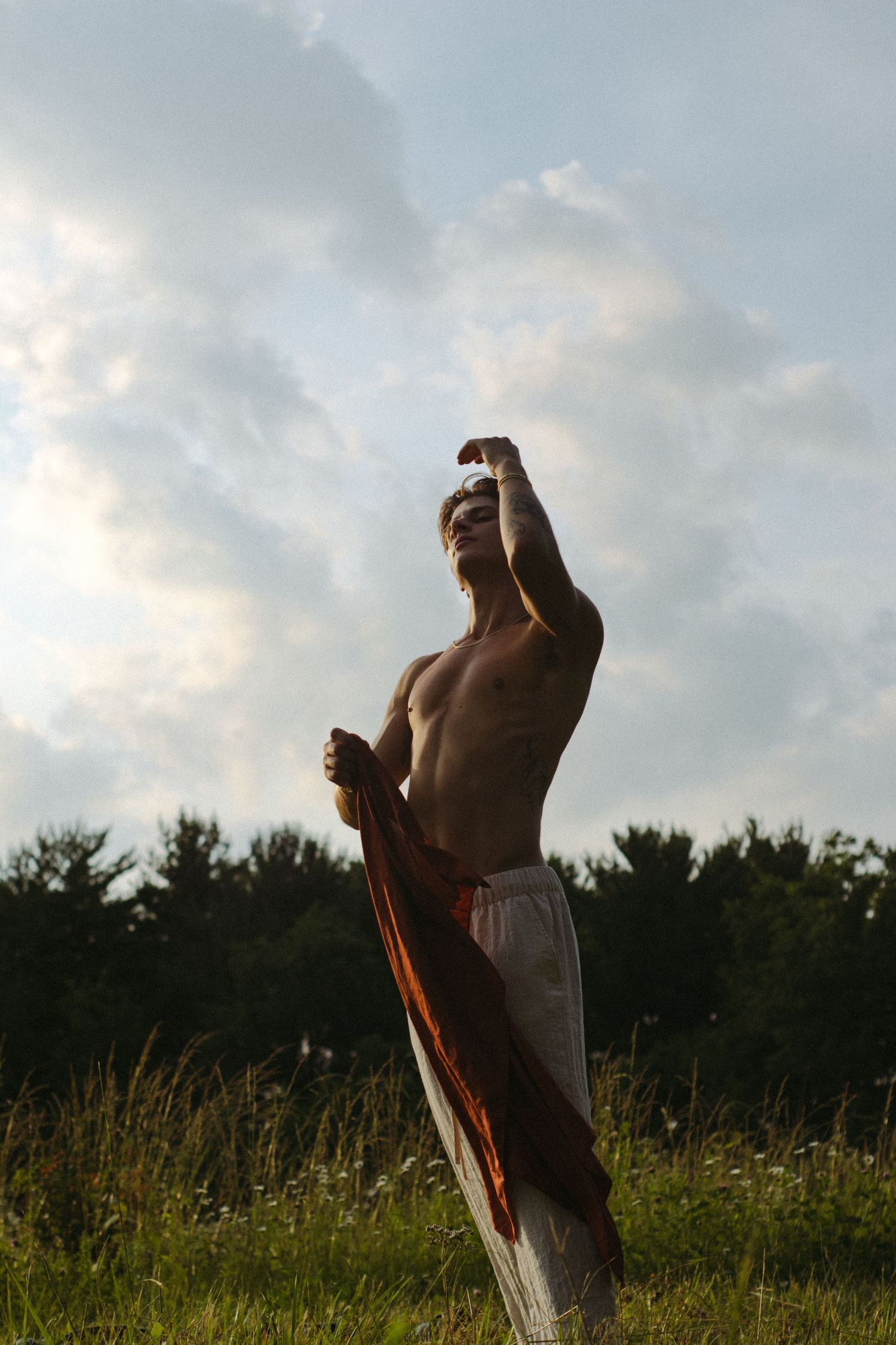 A man standing in a sunlit field.