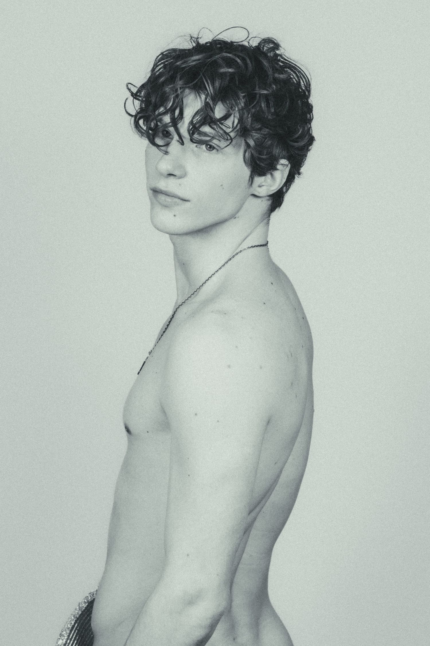 A shirtless man standing in front of a white background
