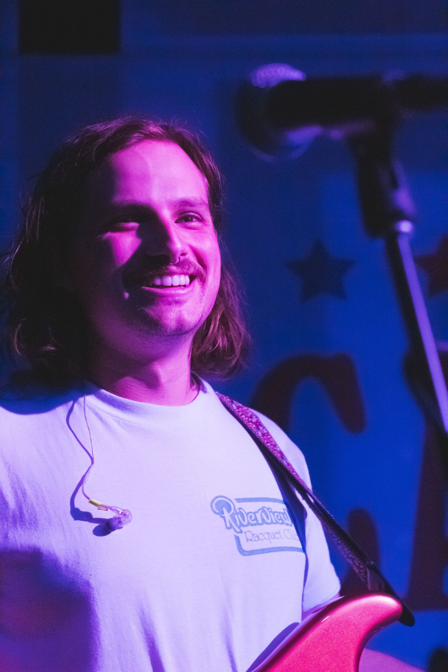 A man smiling near a microphone
