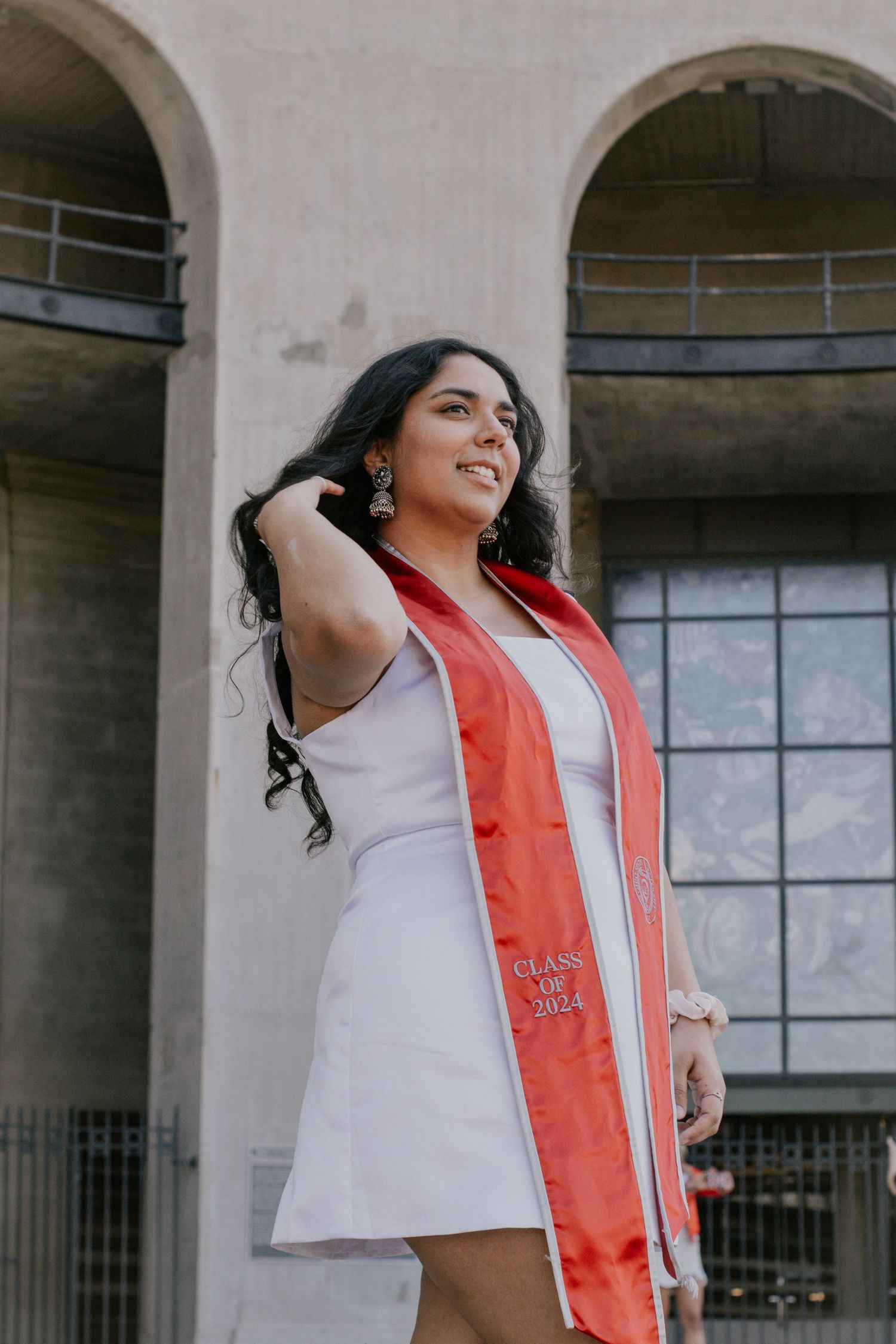 A woman flipping her hair in front of a stone building