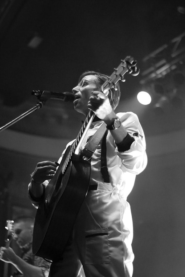 A man playing guitar and singing into a microphone
