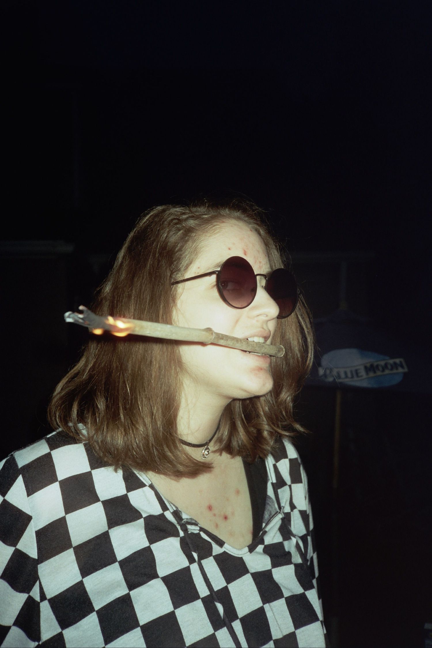 A woman holding a stick on fire in her mouth