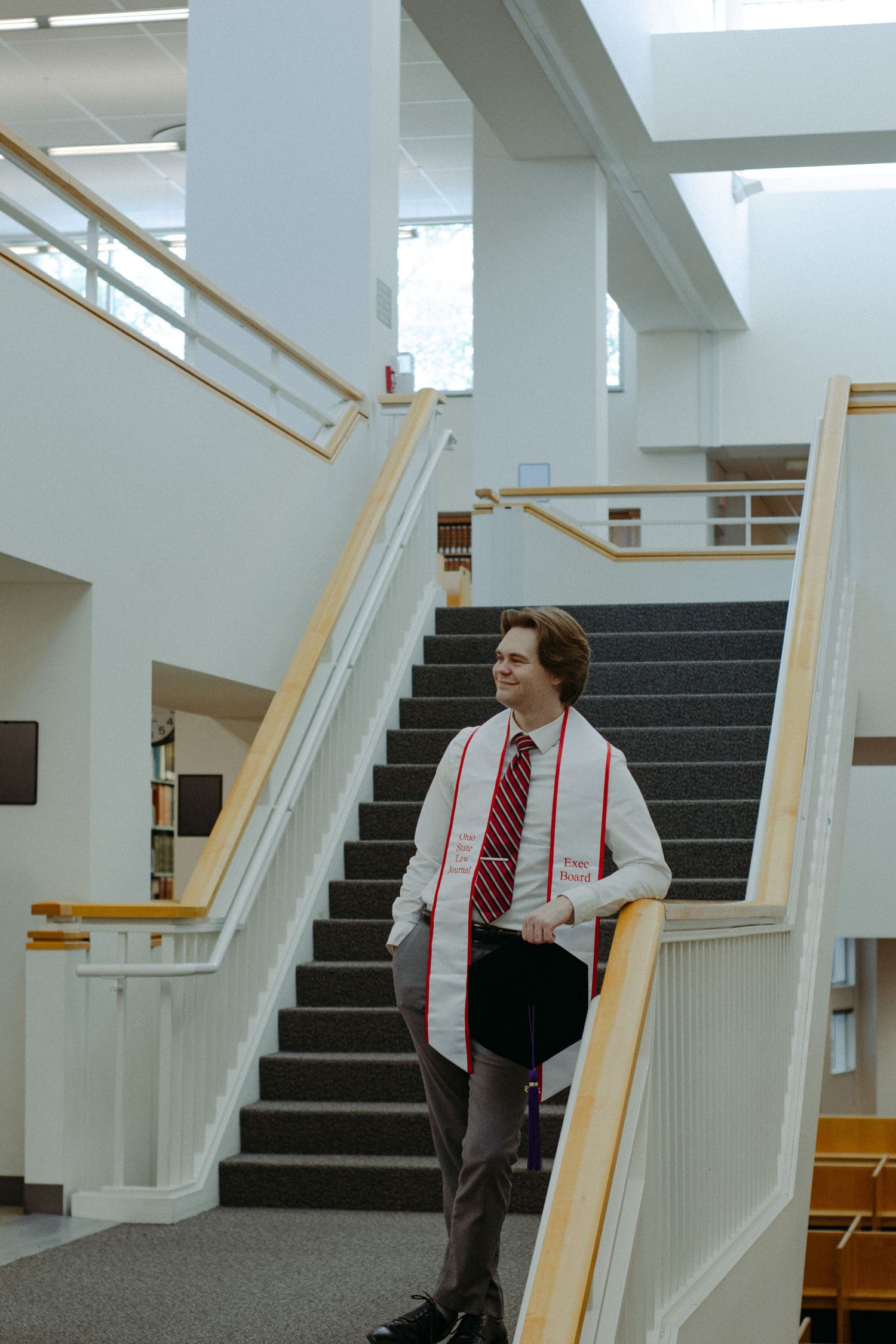 A man standing on the landing of staircase.