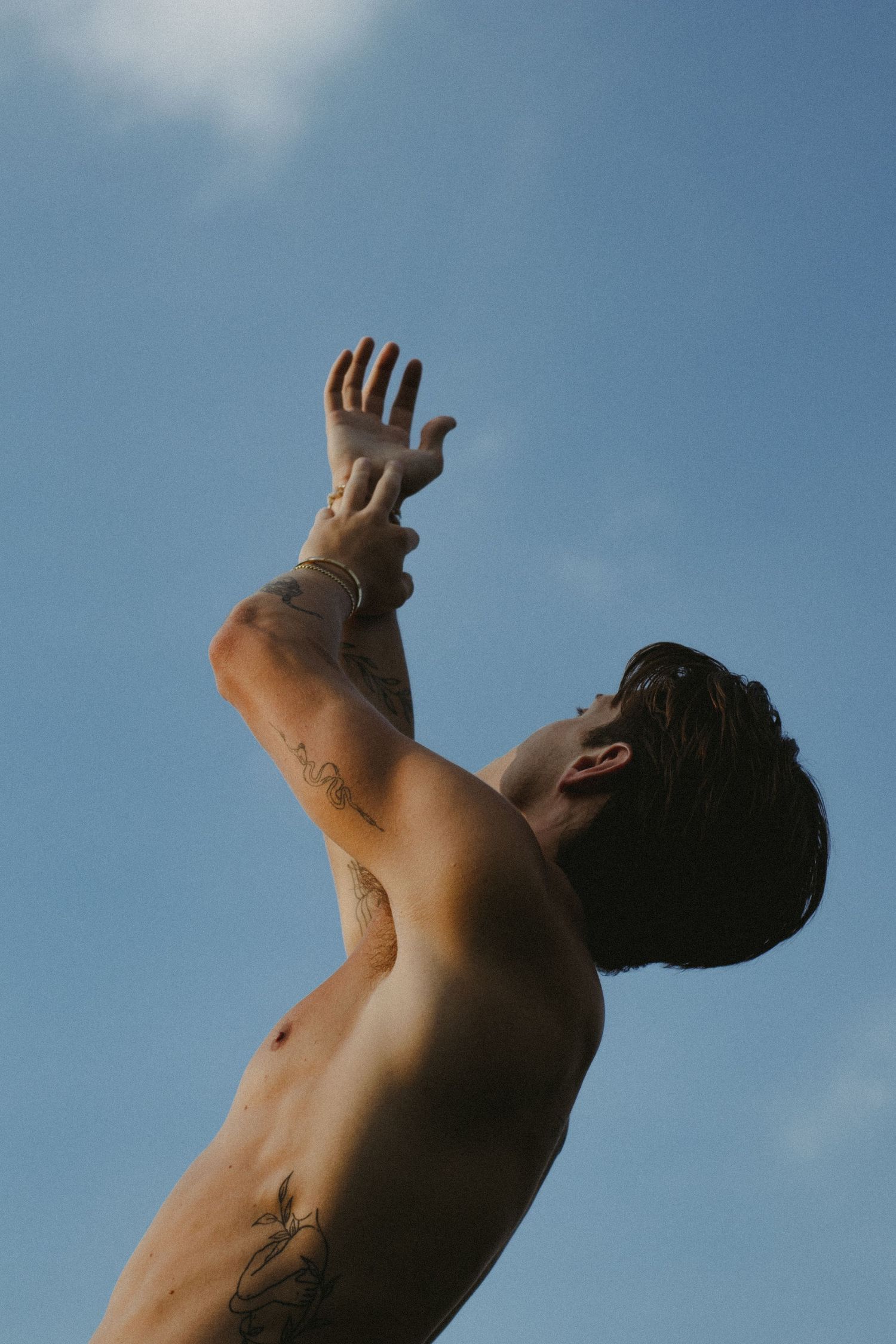 A man with his arms stretching up towards the sky.