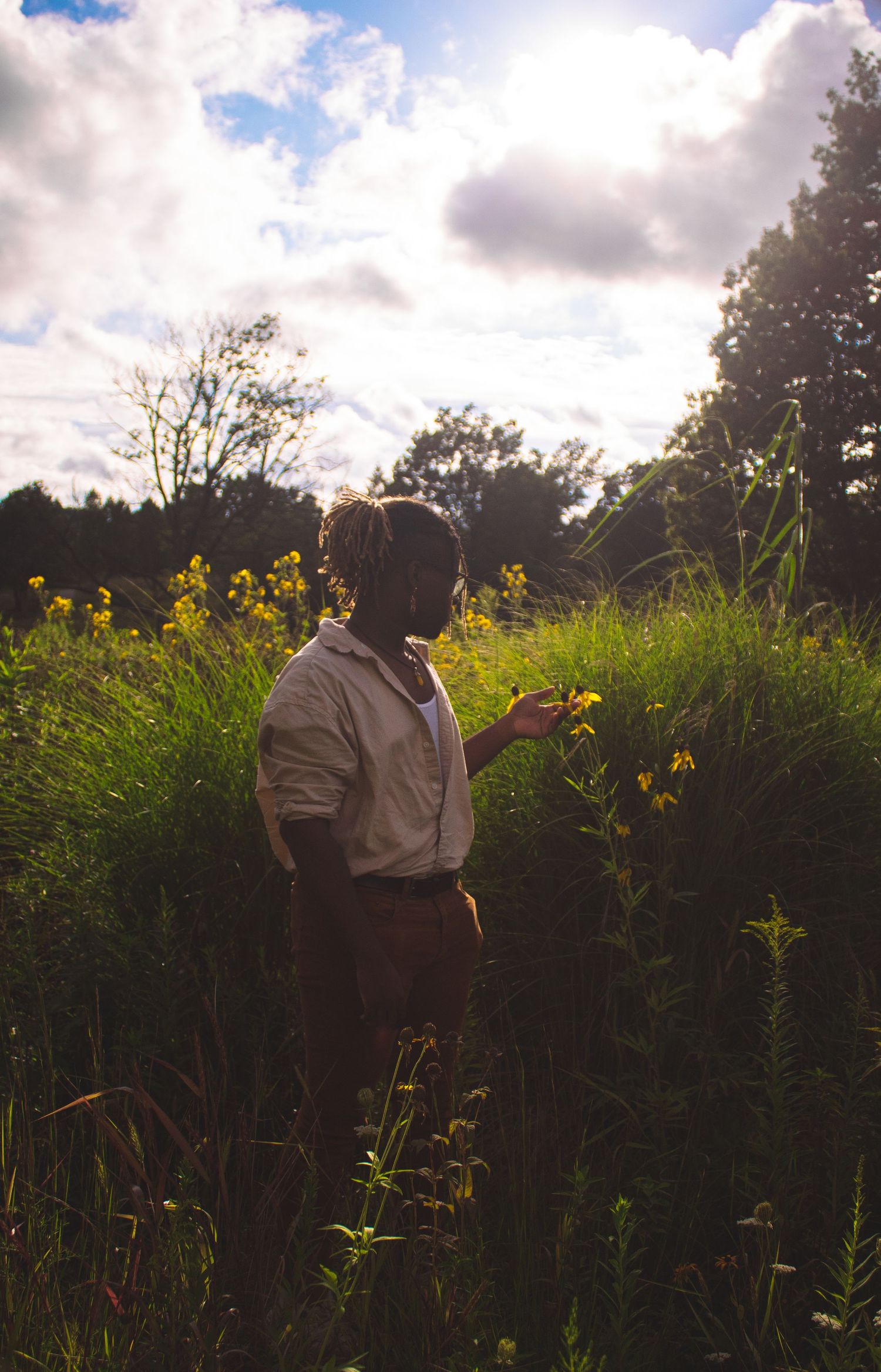 A man standing in a tall grassy field