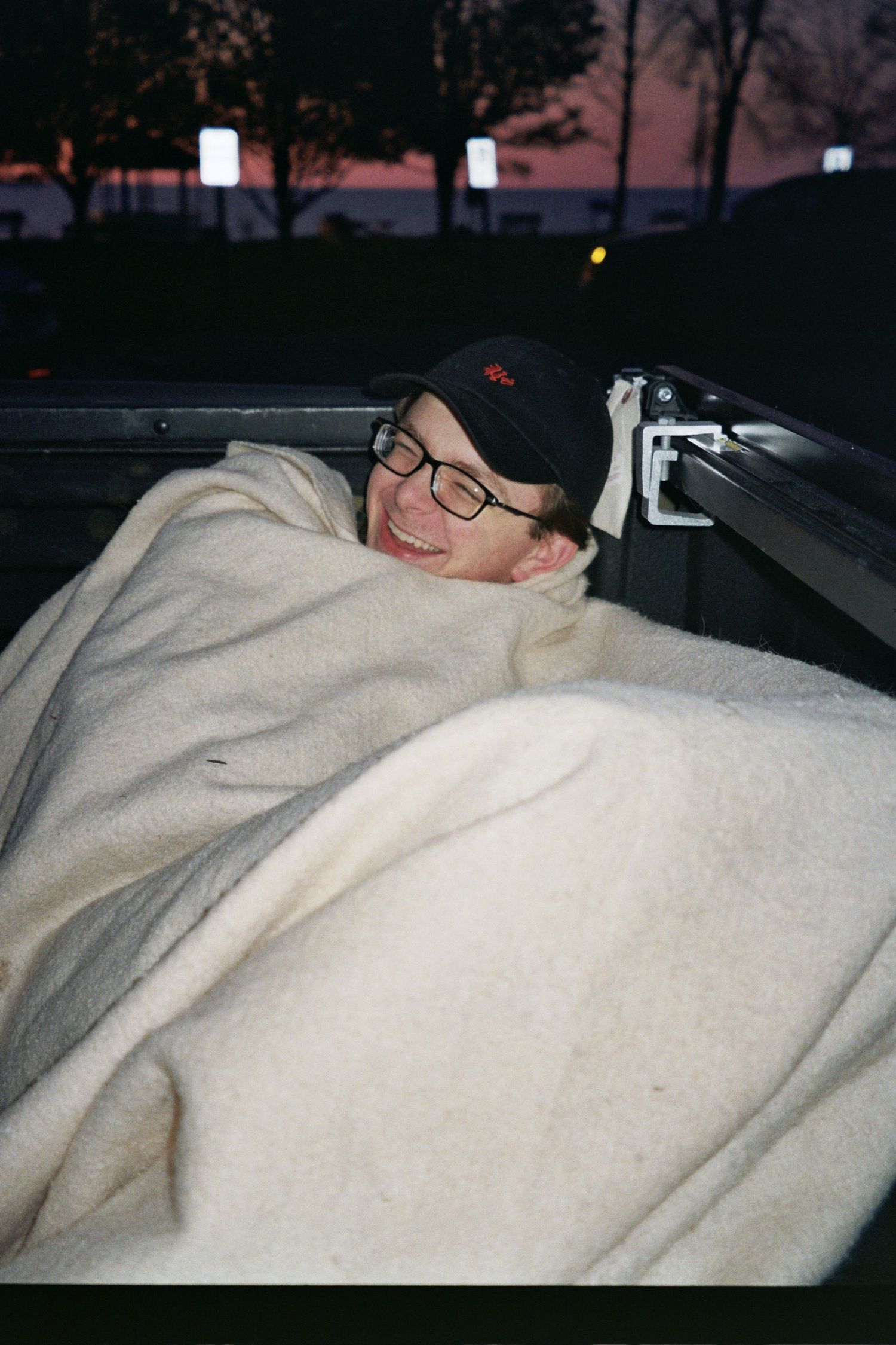 A man under a blanket laughing