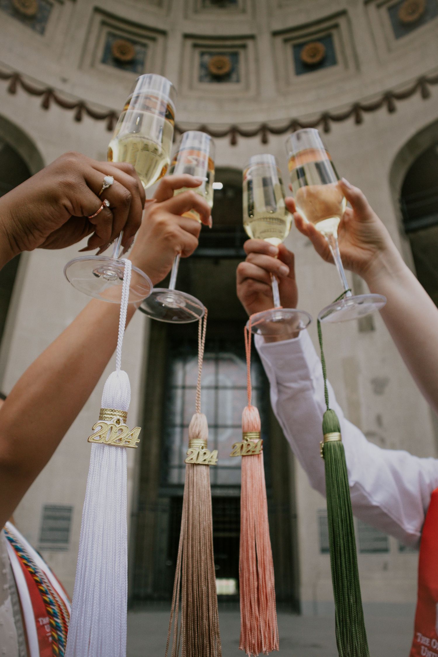 Four champagne glasses with tassels hanging from them