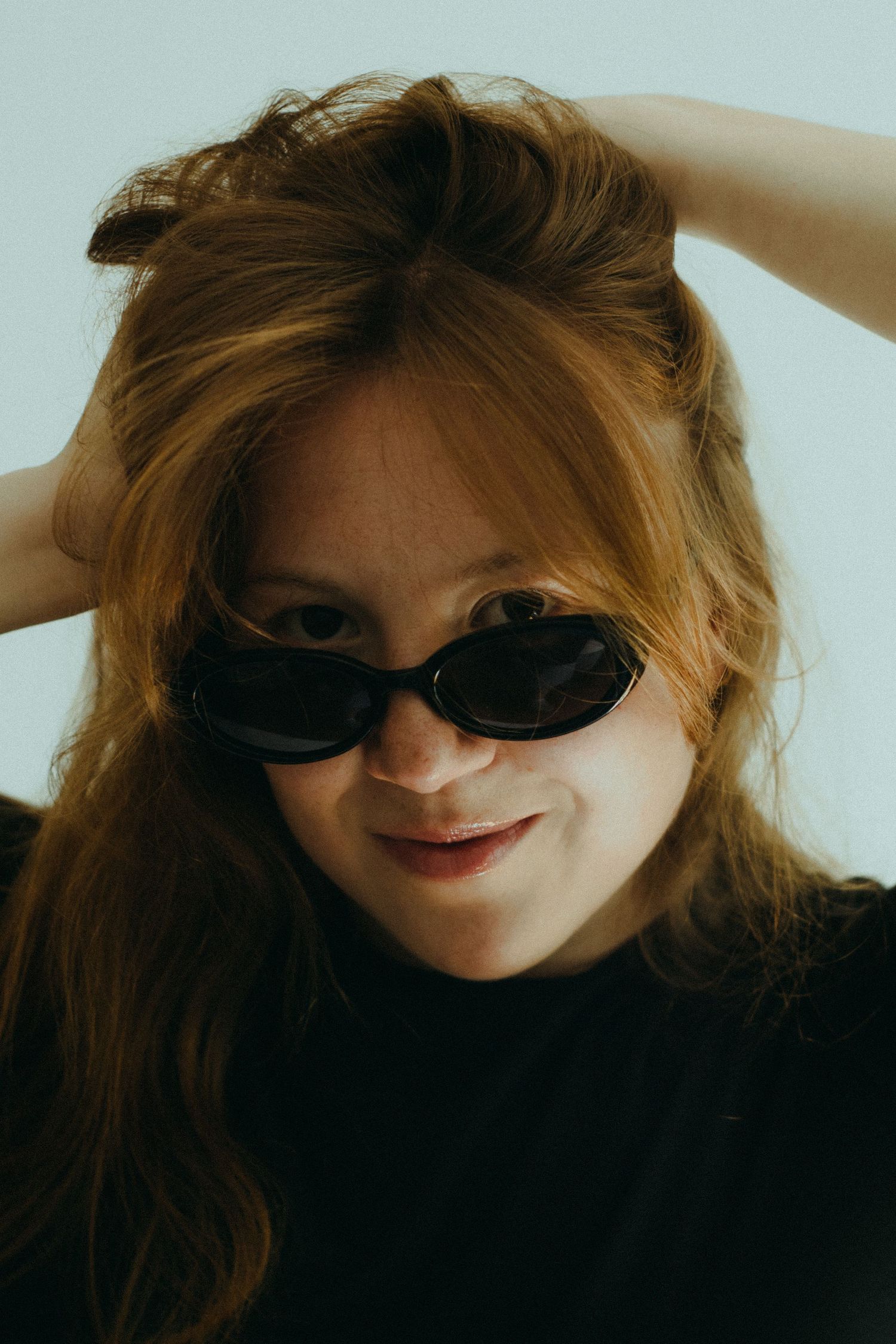 A photo of a woman in a black shirt and black sunglasses.