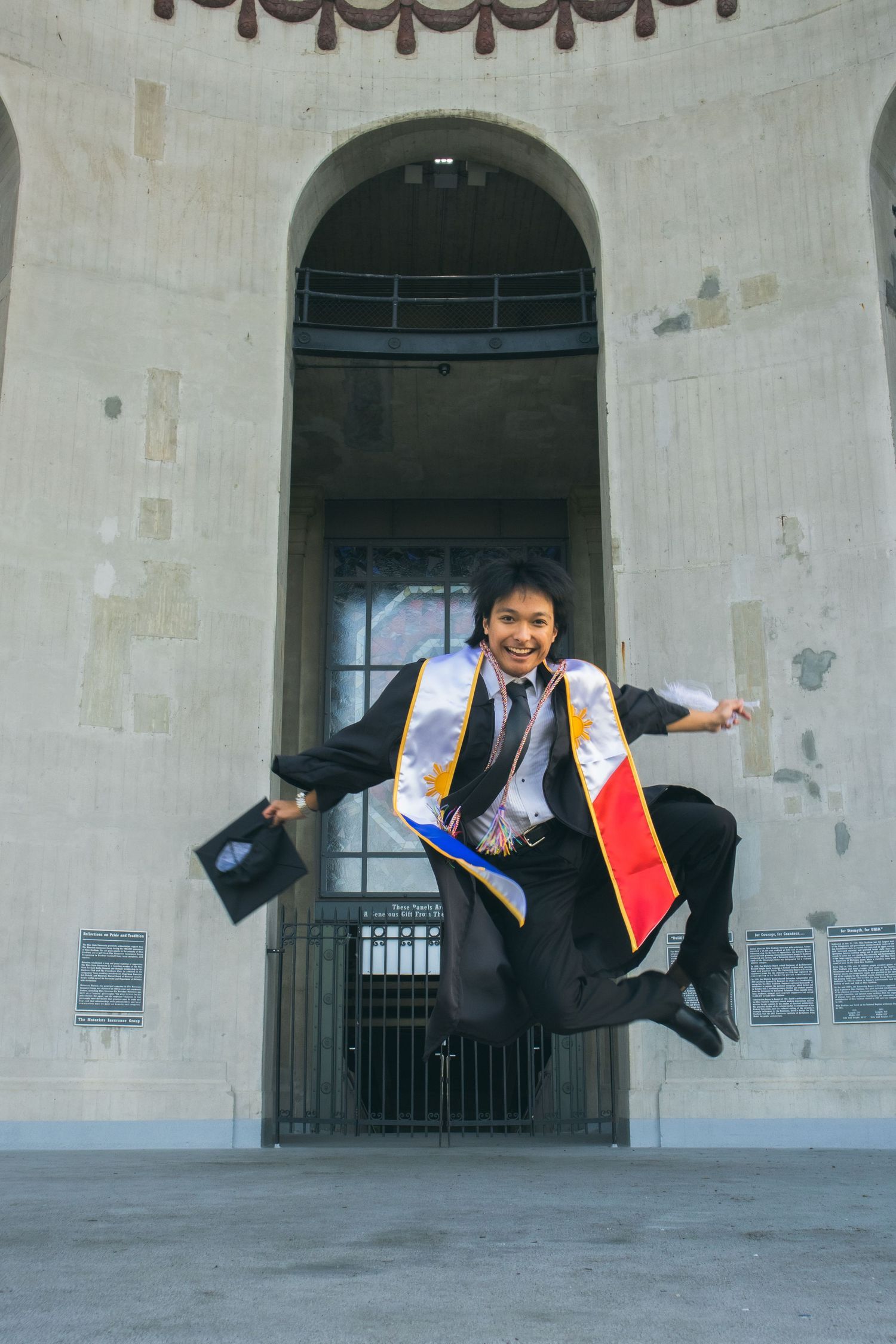 A man jumping in midair with his cap and gown.