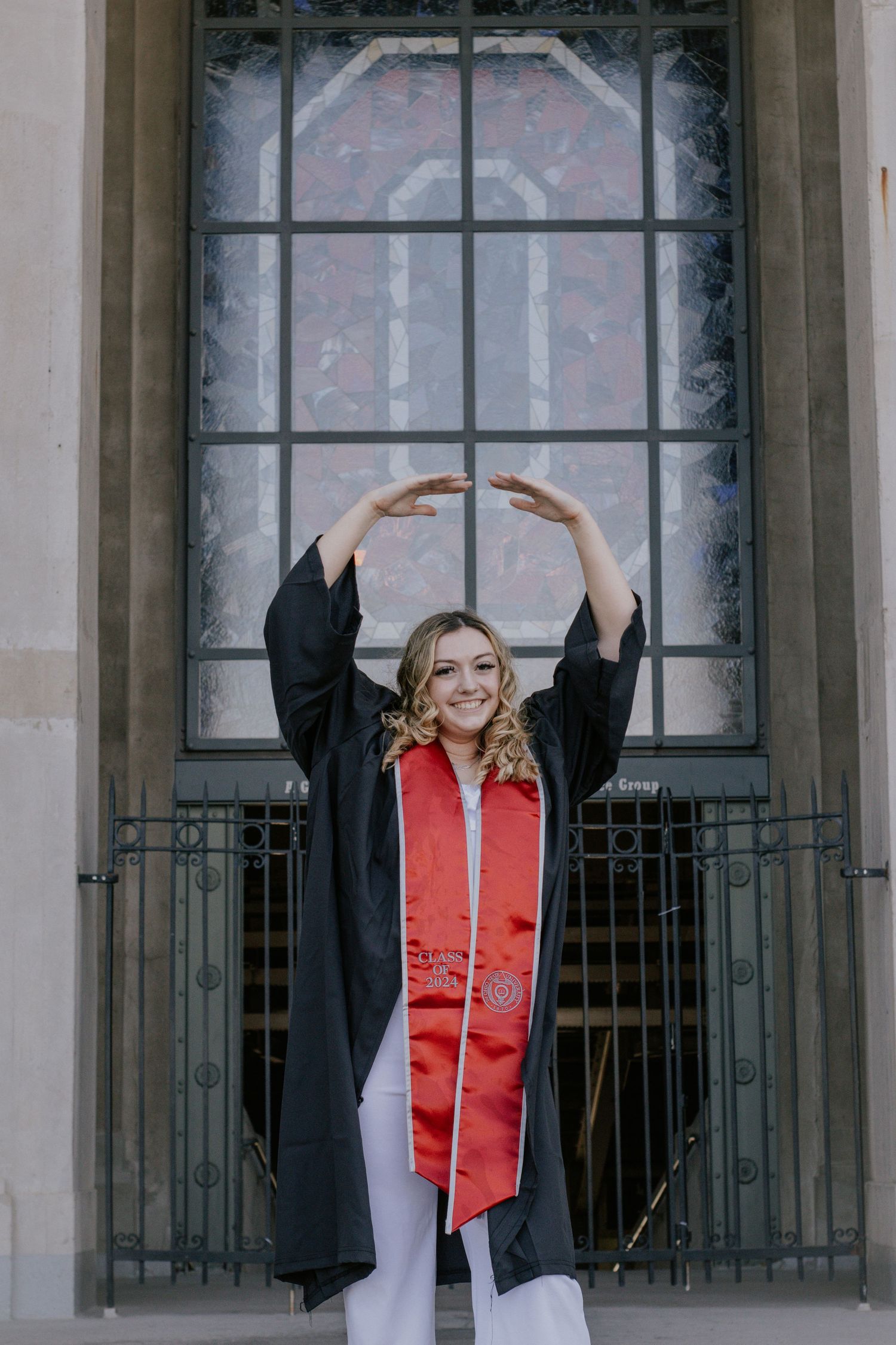 A woman holding her arms up in front of a building