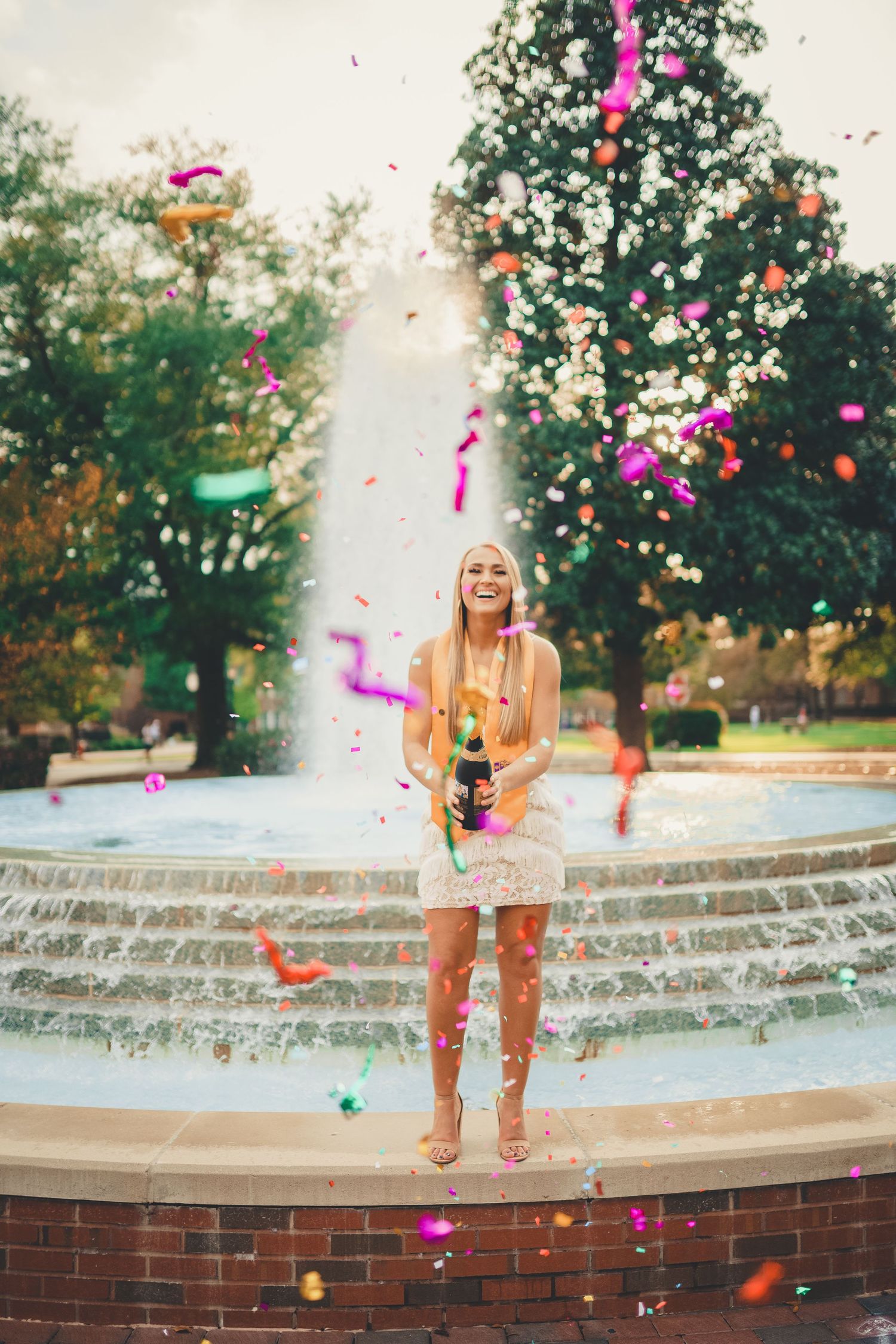 ECU grad session at the wright fountain with purple and gold confetti