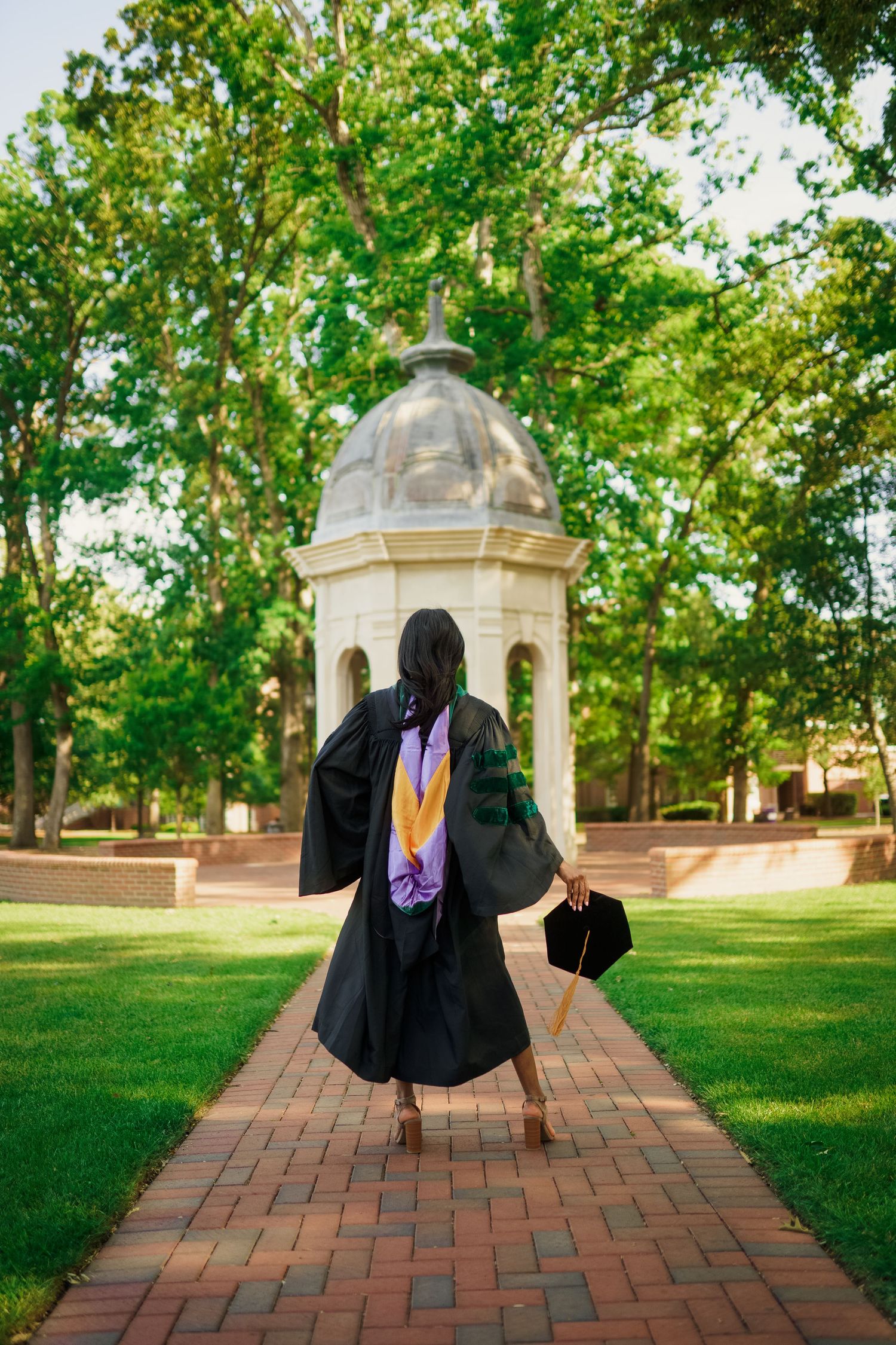 ECU Doctorate Graduate poses on East carolina university's campus for the best ECU grad photos by Joan Avilez Photography. At the ECU Cupola