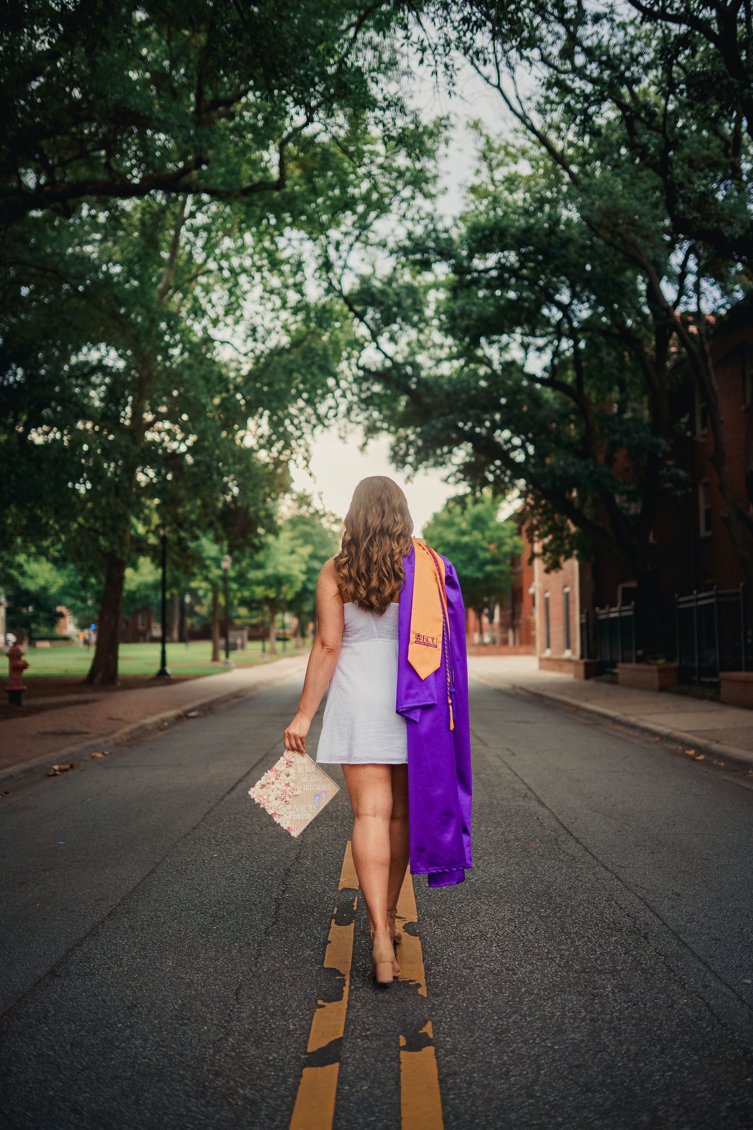 ECU Graduate poses on East carolina university's campus for the best ECU grad photos by Joan Avilez Photography