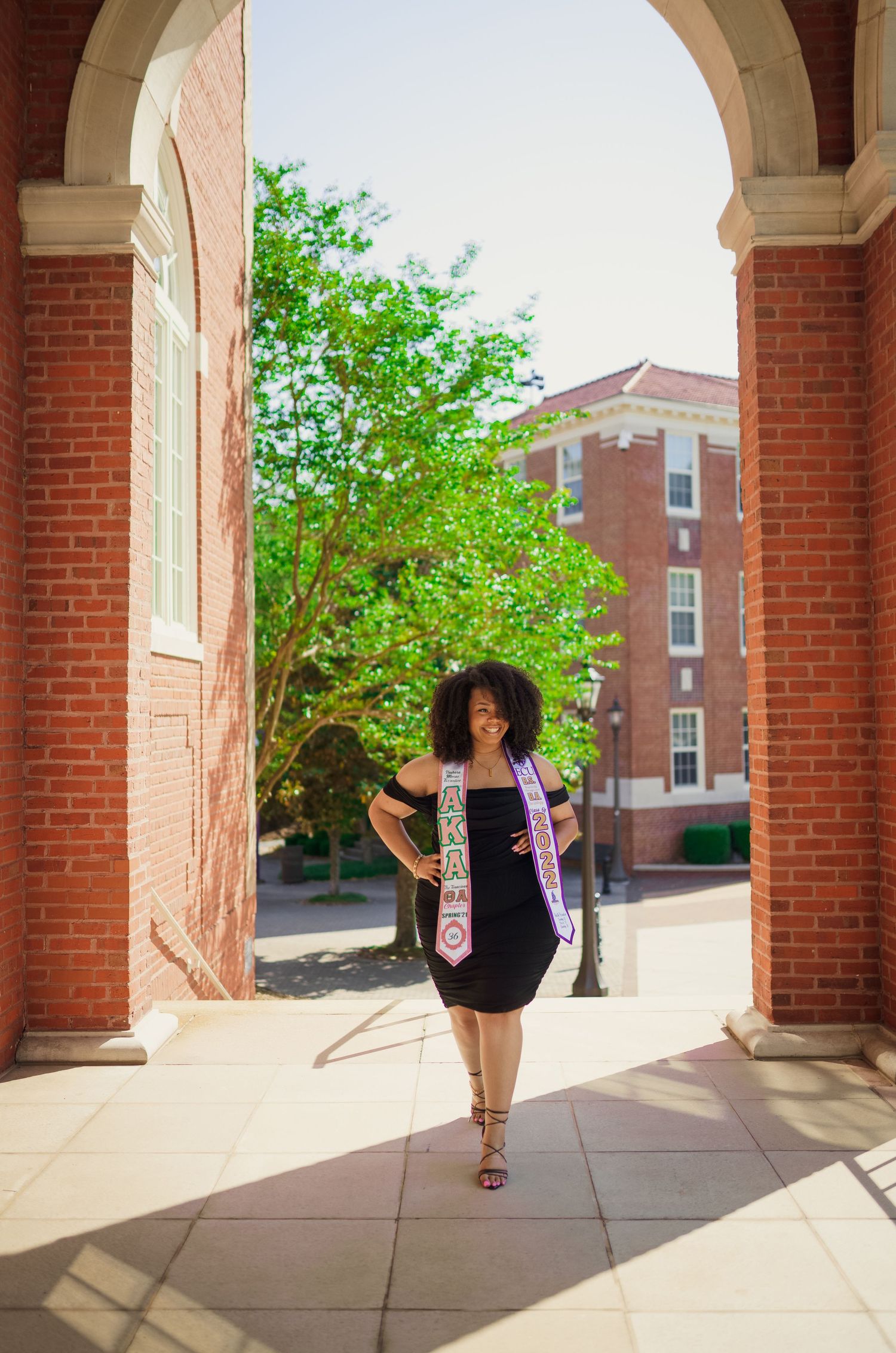 ECU Graduate poses on East carolina university's campus for the best ECU grad photos by Joan Avilez Photography at the wright building