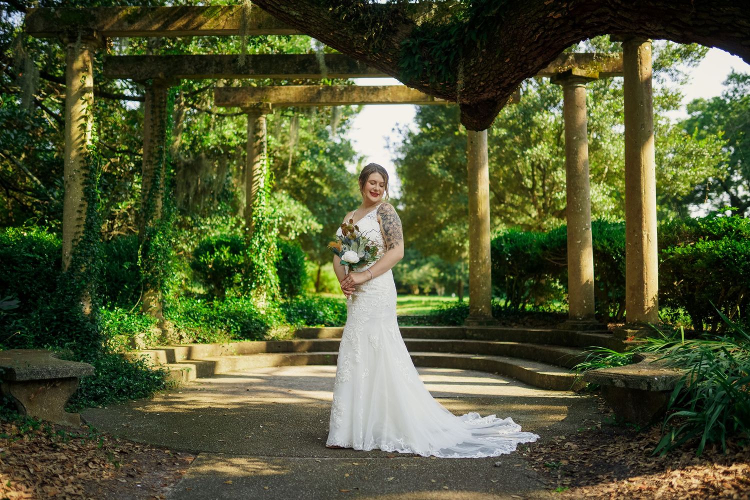 Elegant bridal photo in a lush garden setting beneath a vine-covered archway.