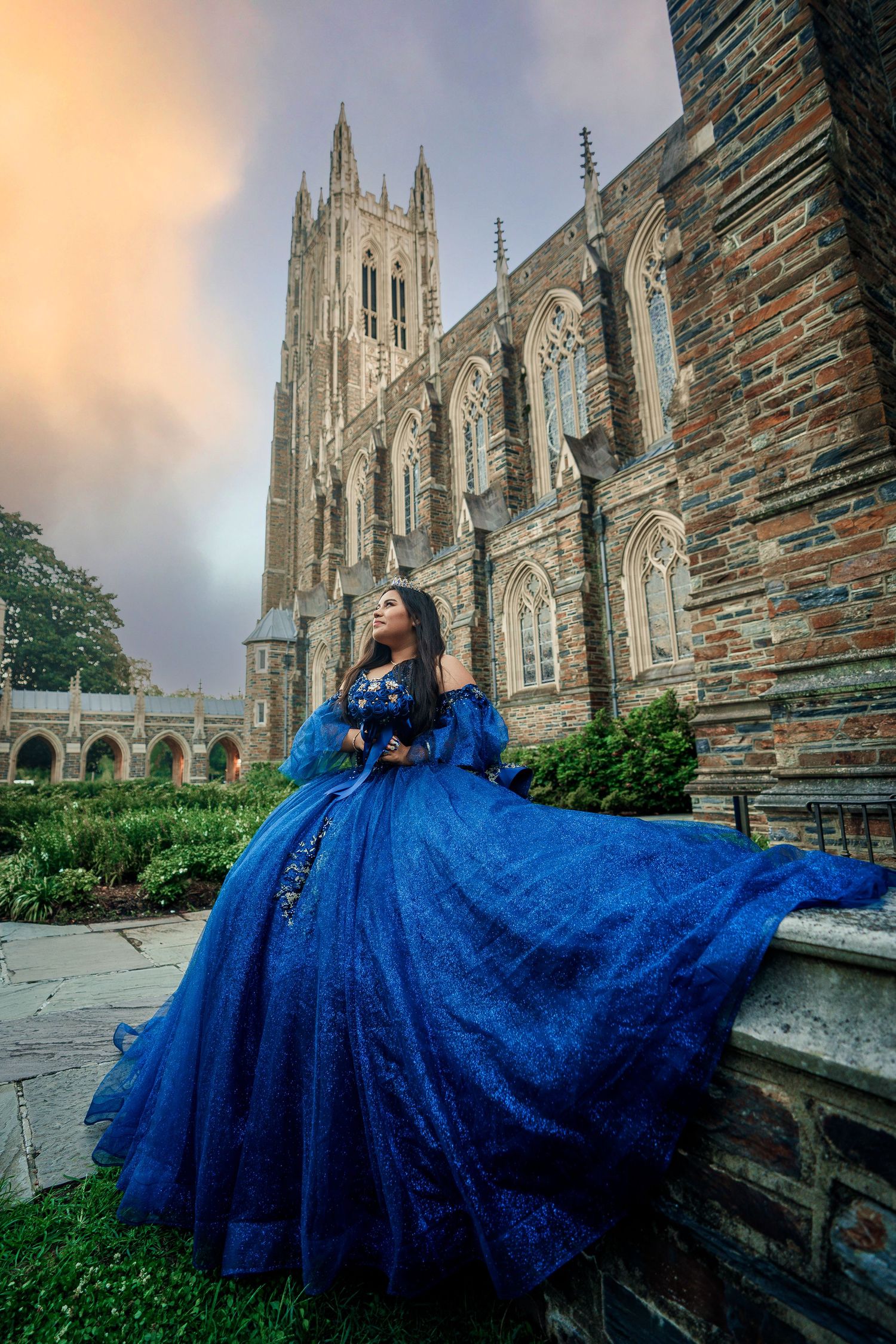 Stunning blue gown contrasts against stone Gothic architecture in dramatic fashion photo.