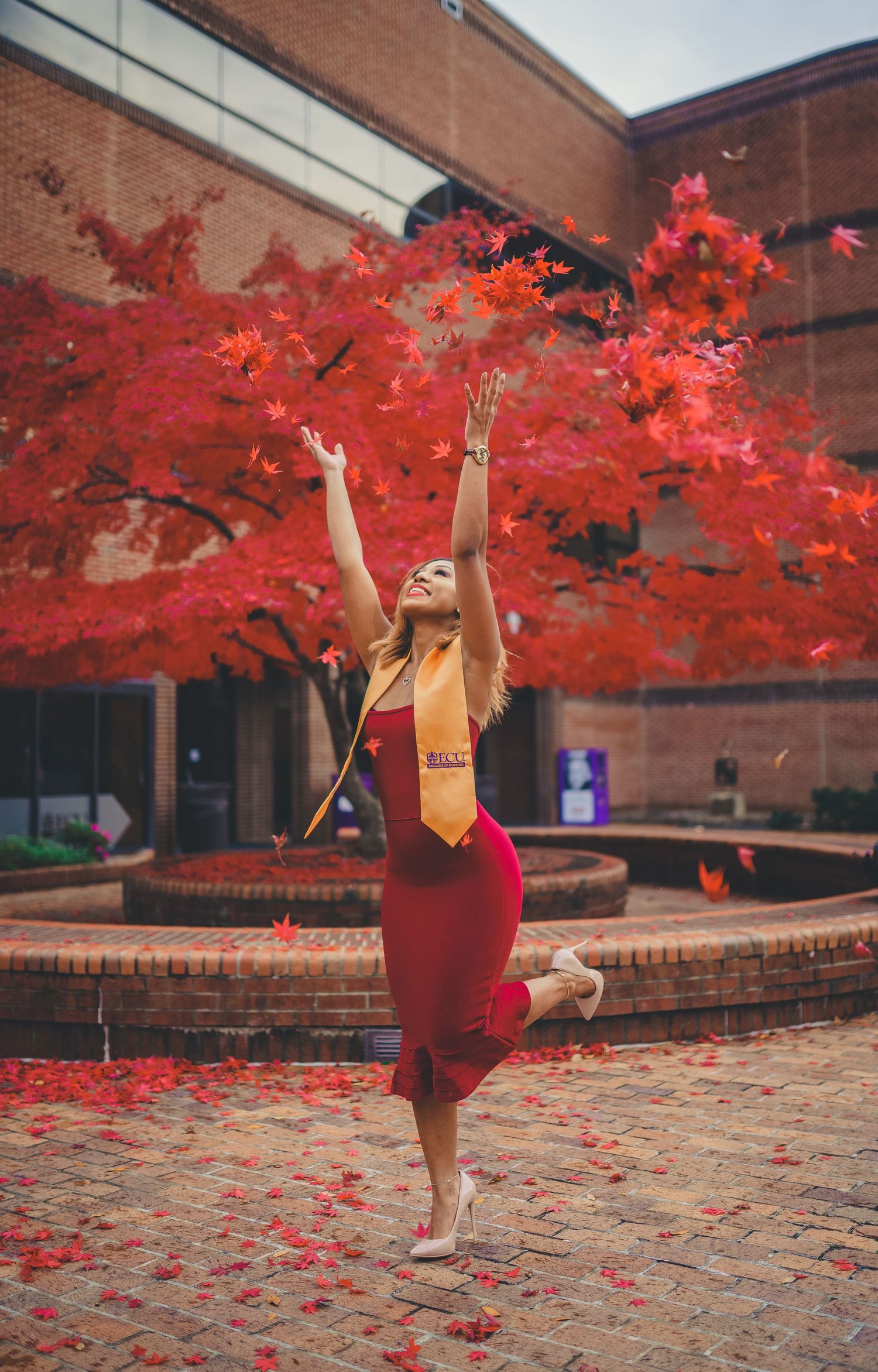 East Carolina University graduate celebrating in front of Bate building with Gold Stole.