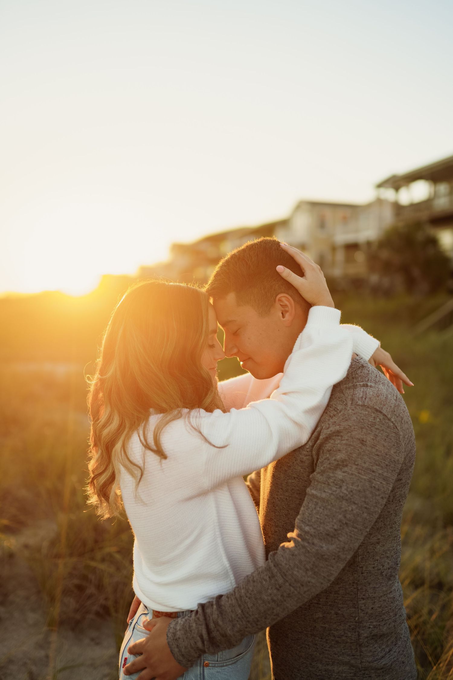 A couple sharing an intimate moment at sunset on the beach.