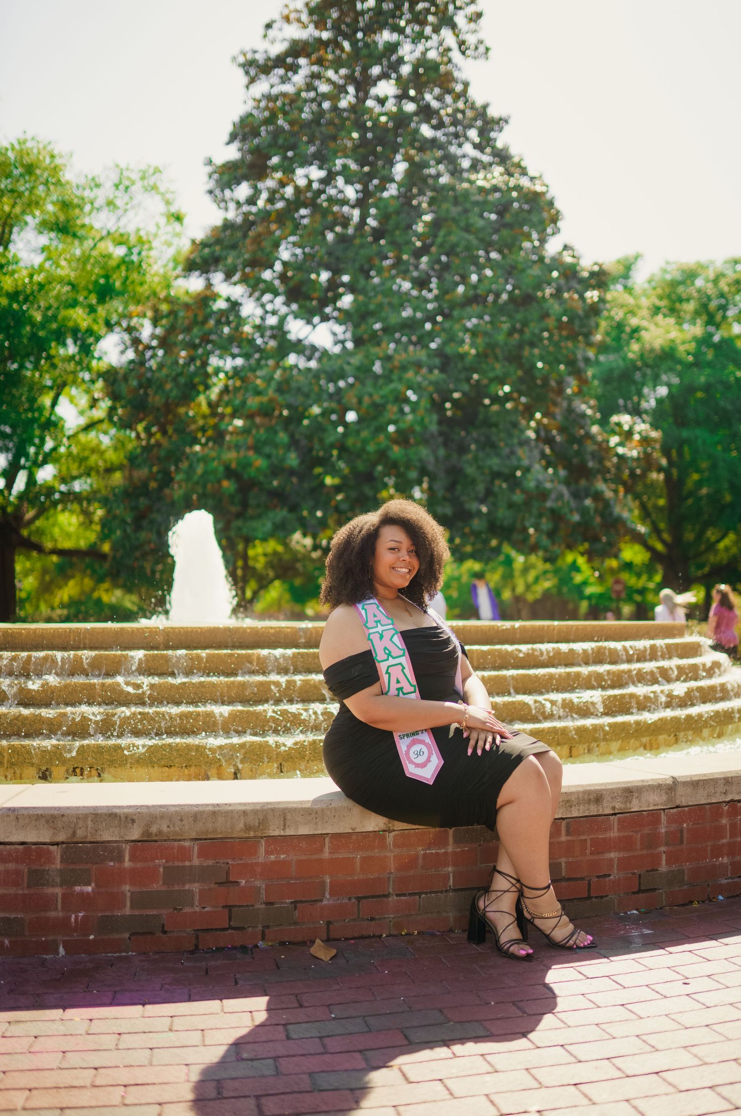 ECU Graduate poses on East carolina university's campus for the best ECU grad photos by Joan Avilez Photography. at the wright fountain