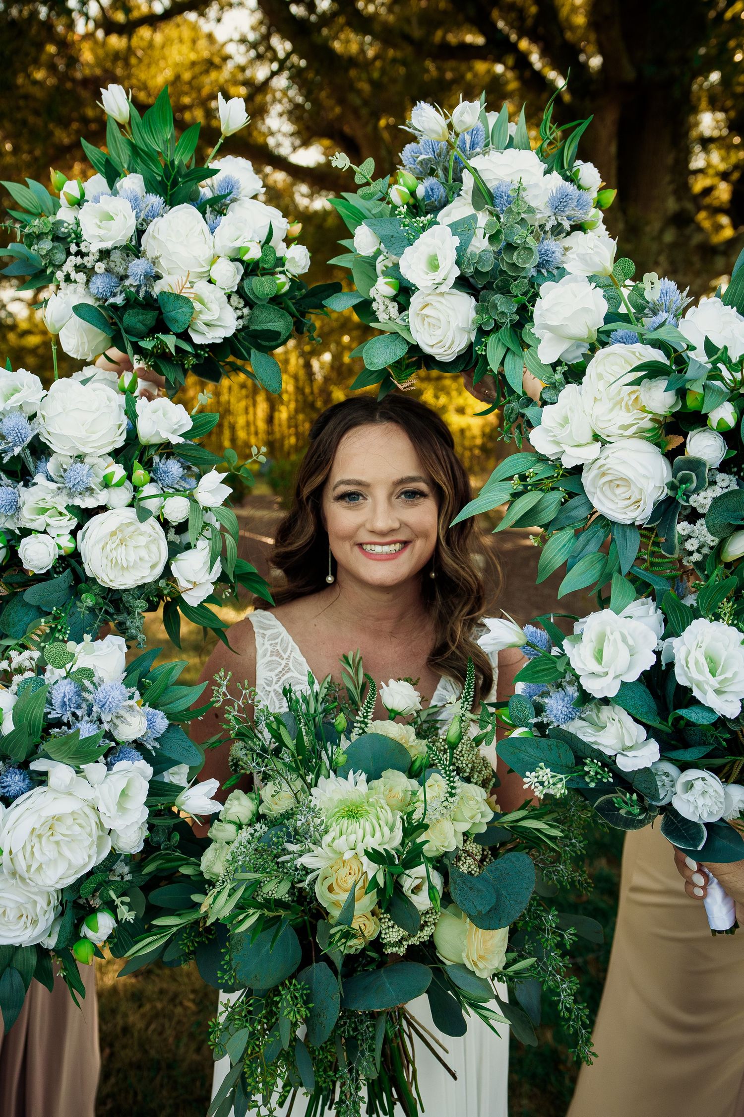 Beautiful white rose and eucalyptus floral arrangements frame the scene outdoors.