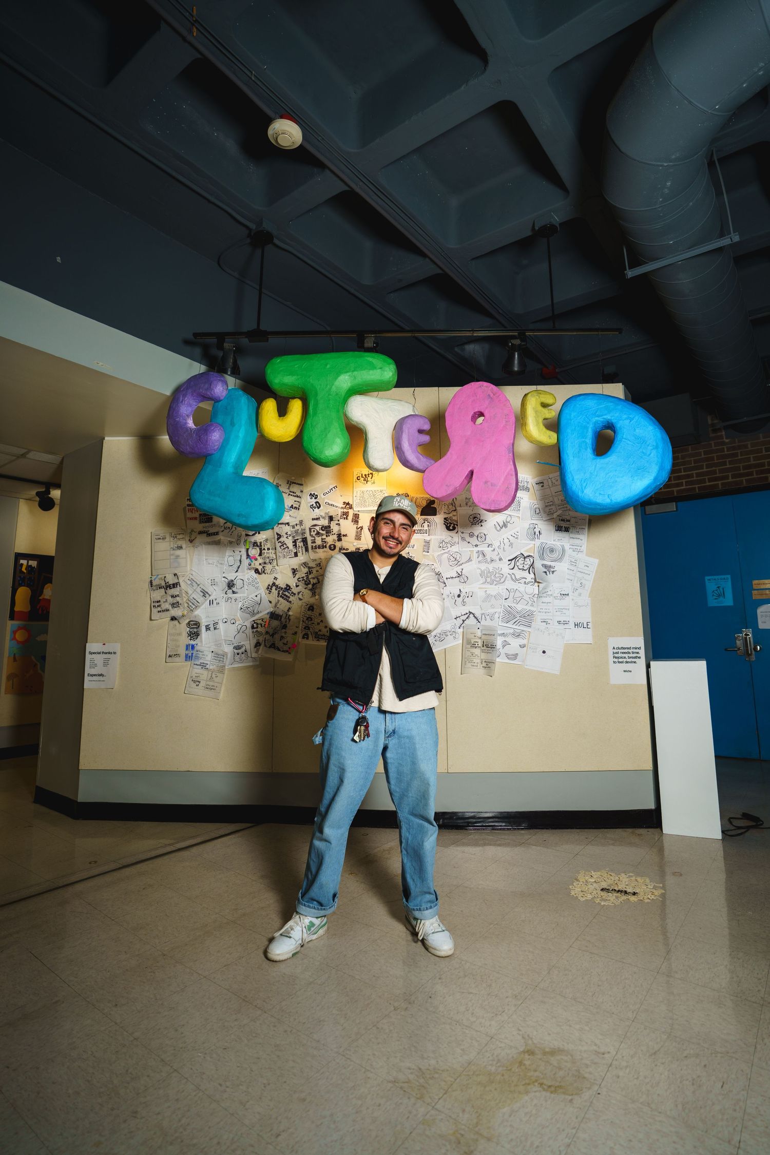 Figure poses beneath colorful balloon lettering against a wall decorated with sketches.