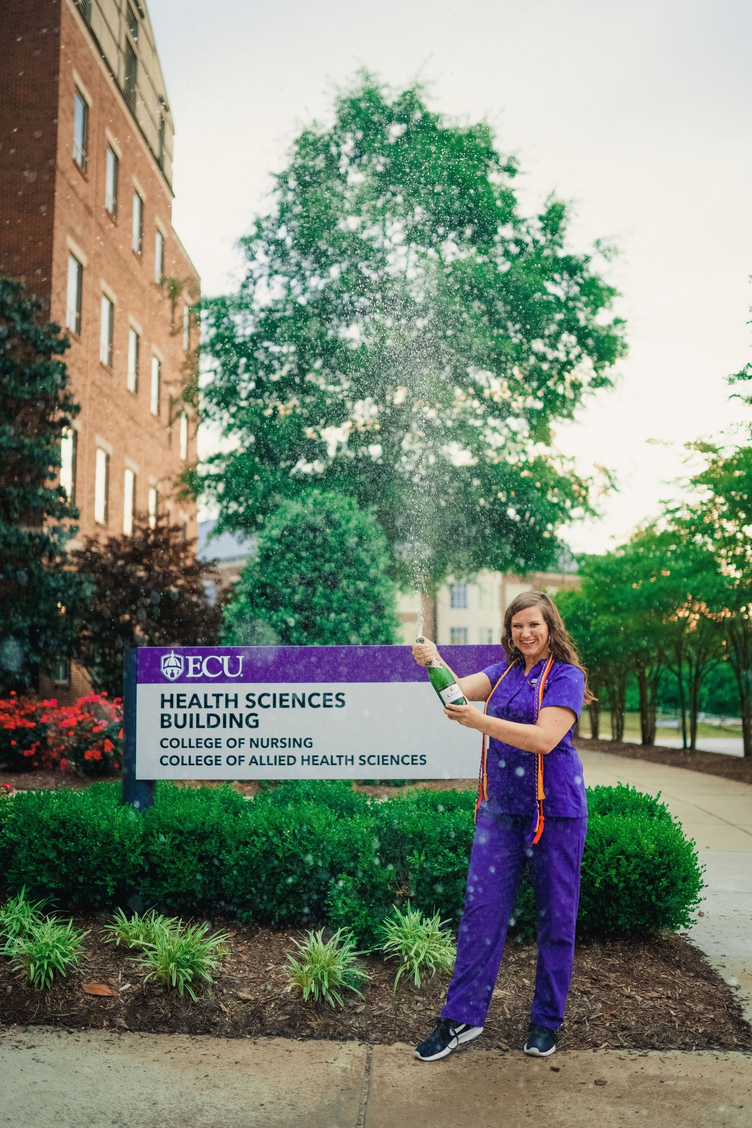 ECU Graduate poses on East carolina university's health science campus for the best ECU grad photos by Joan Avilez Photography. nursing