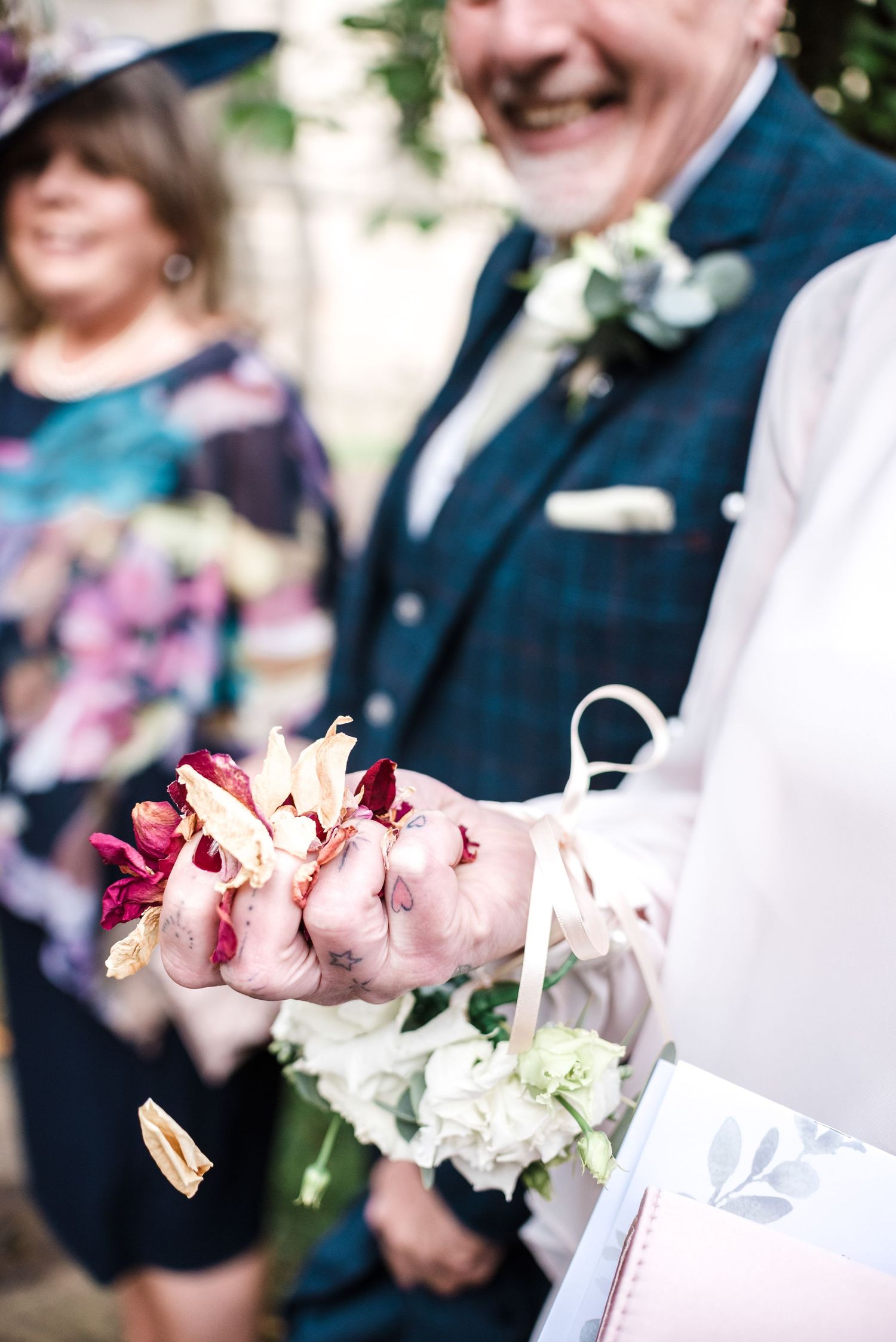 Wedding guests holding delicate pink flower petals during the celebration.