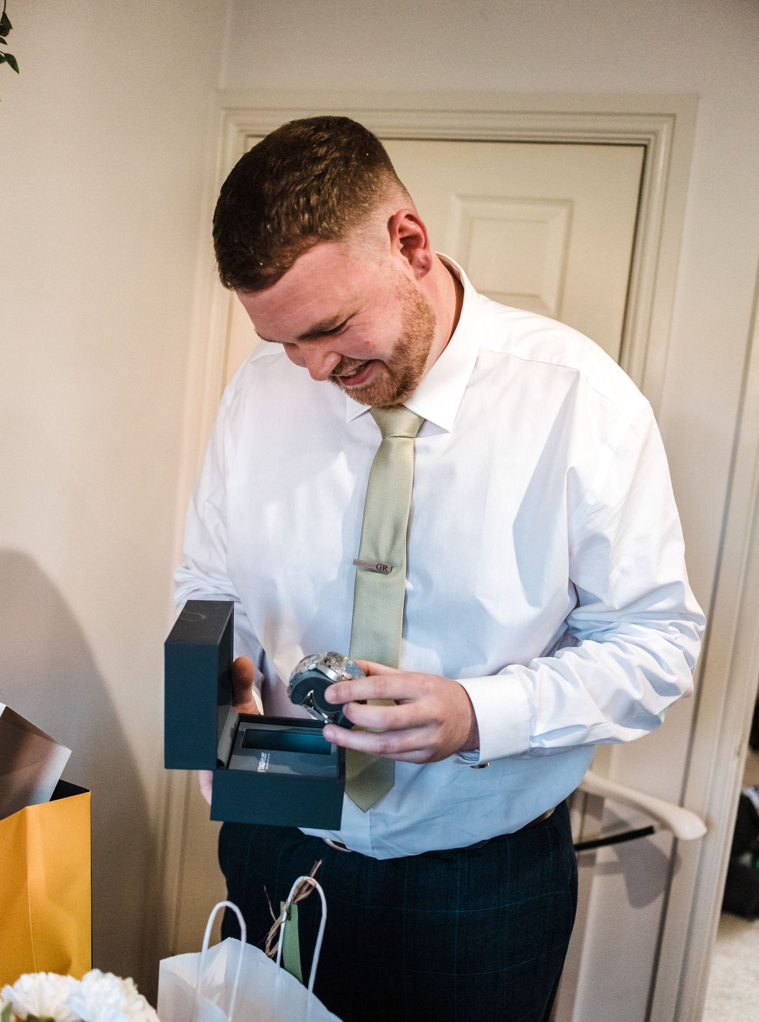 Wedding morning preparations showing a traditionally dressed person opening a small gift box.
