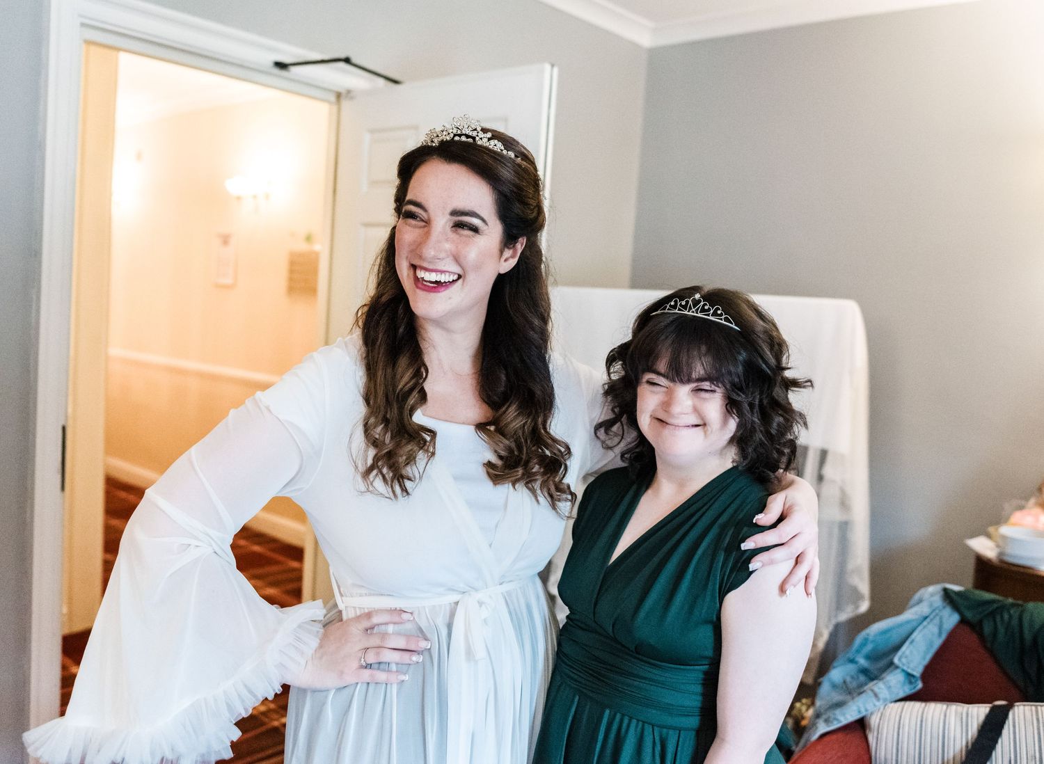 Happy wedding preparation moment showing friendship and celebration in a bright room.