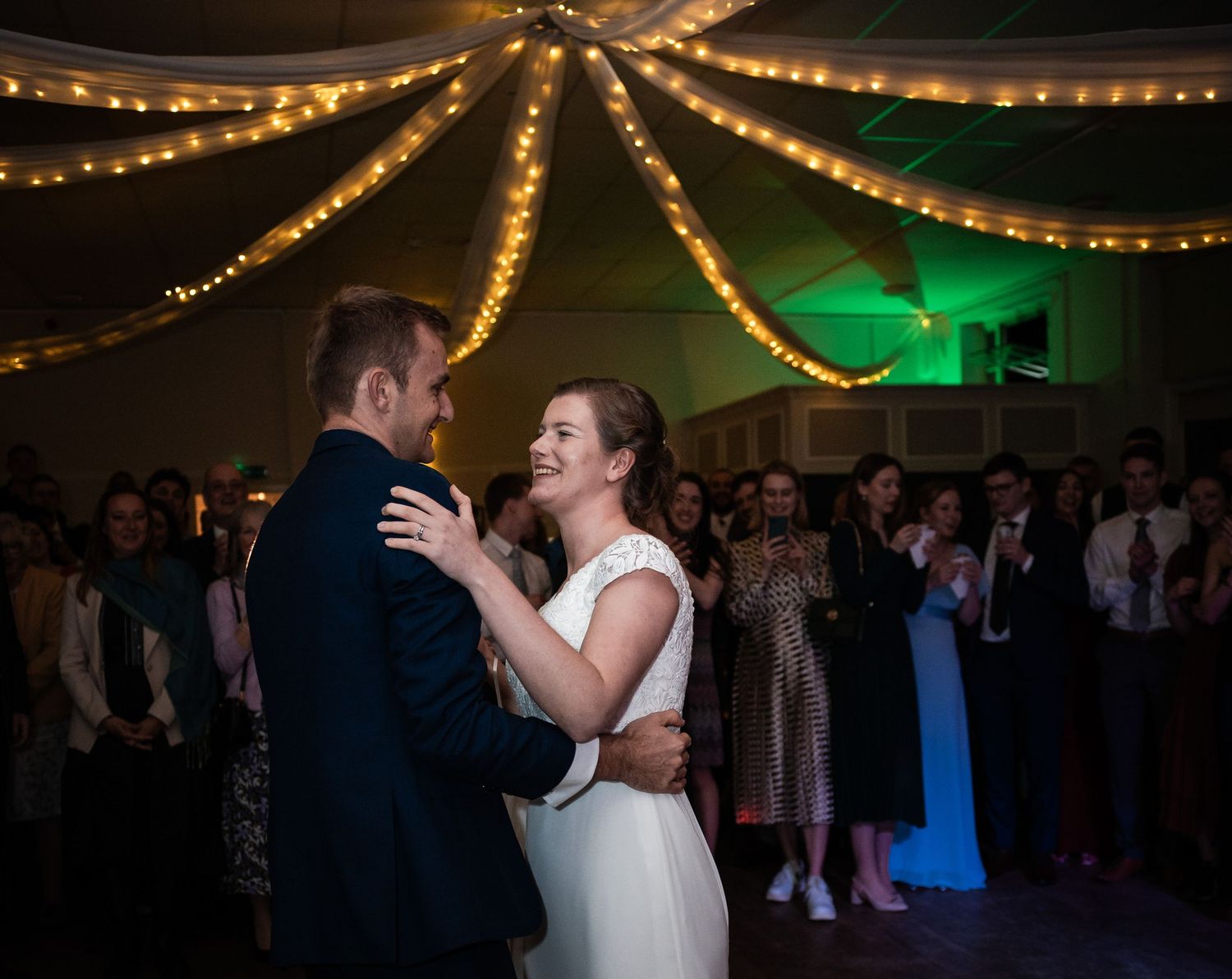 Wedding dance floor under warm string lights creating a romantic ambiance.