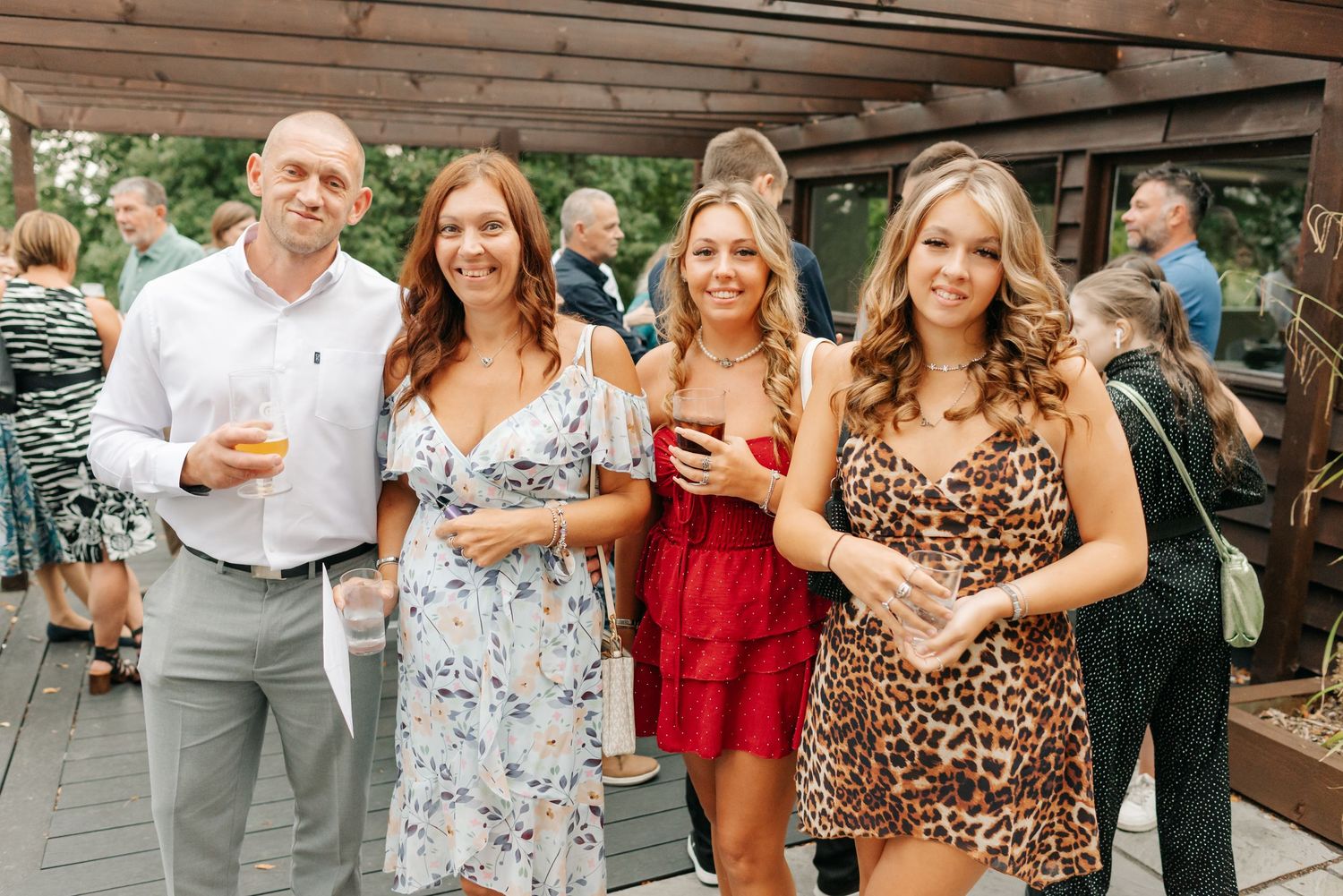 Wedding guests in summer dresses mingle and socialize at outdoor cocktail hour.
